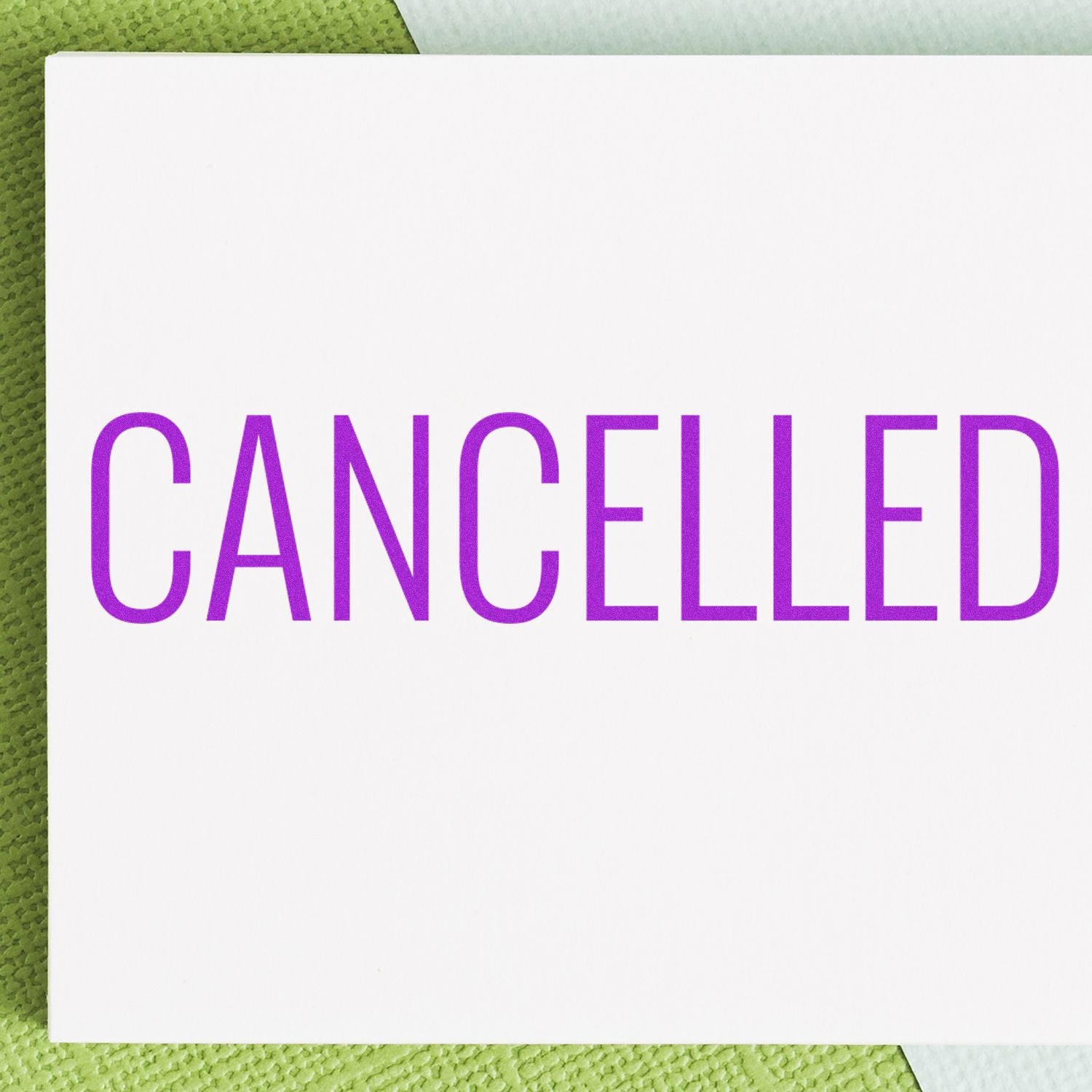 Large Narrow Font Cancelled Rubber Stamp in use, displaying the word CANCELLED in bold purple letters on a white card background.