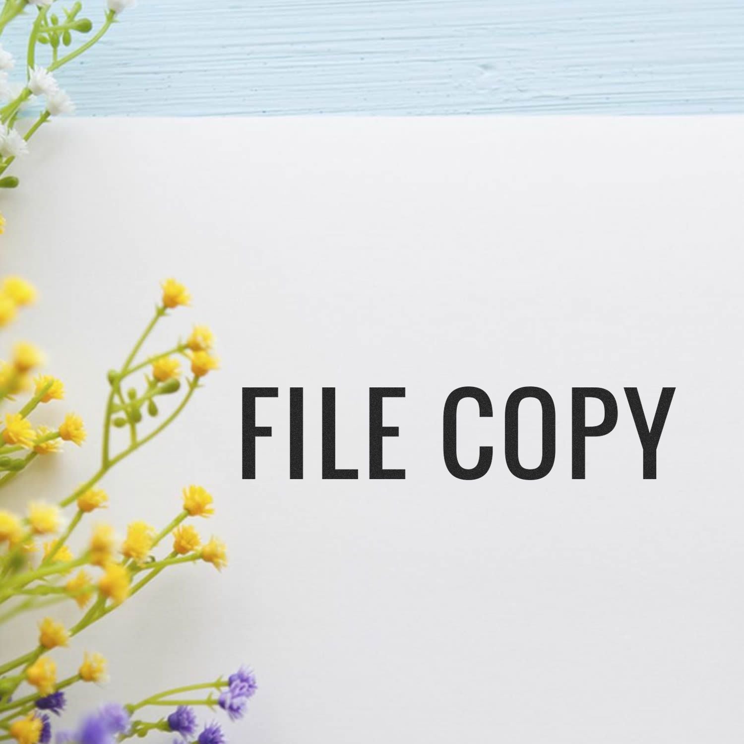 Large Pre-Inked Narrow Font File Copy Stamp marking FILE COPY on paper, with yellow and purple flowers on the side.