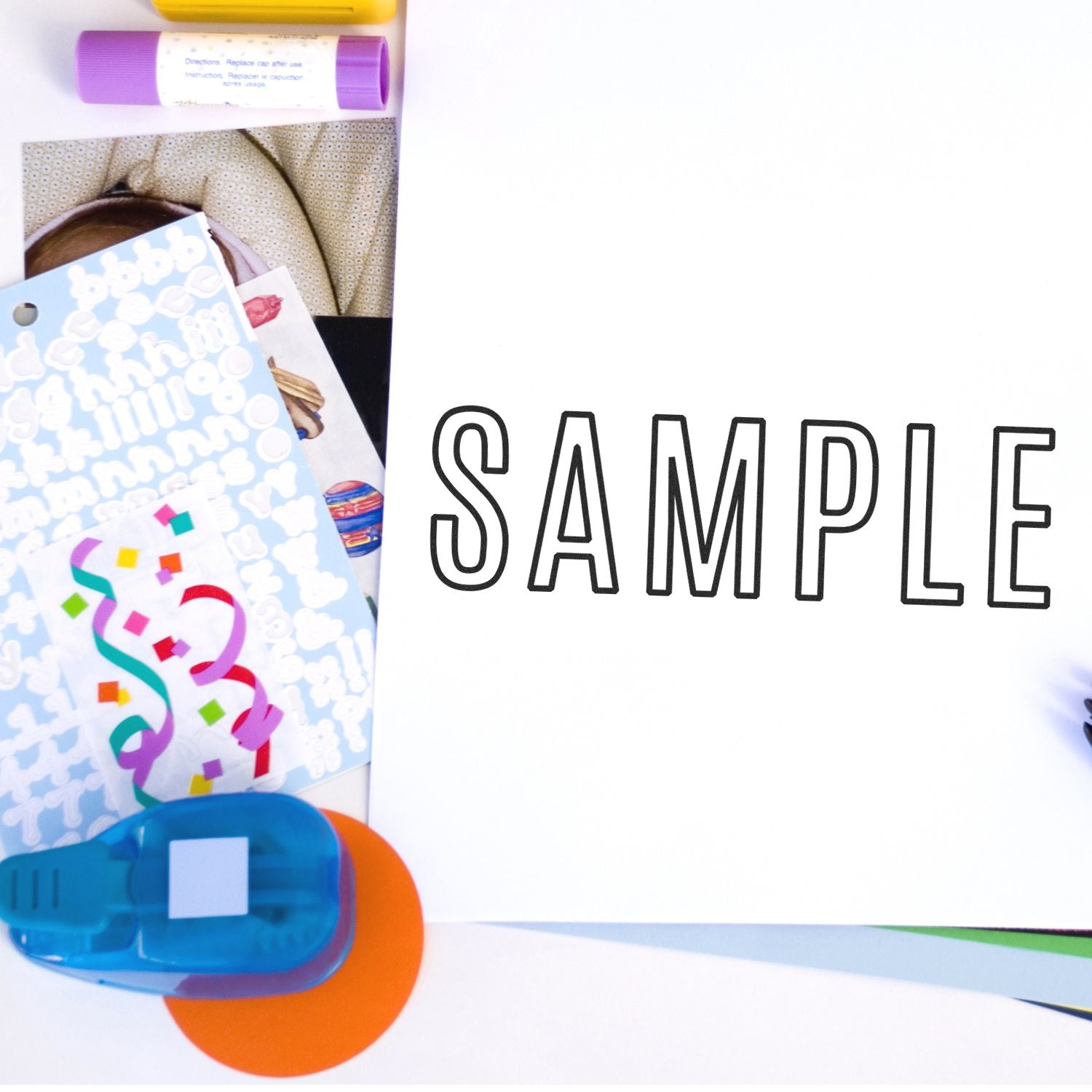 Slim Pre-Inked Outline Sample Stamp used on white paper, surrounded by colorful stationery items.