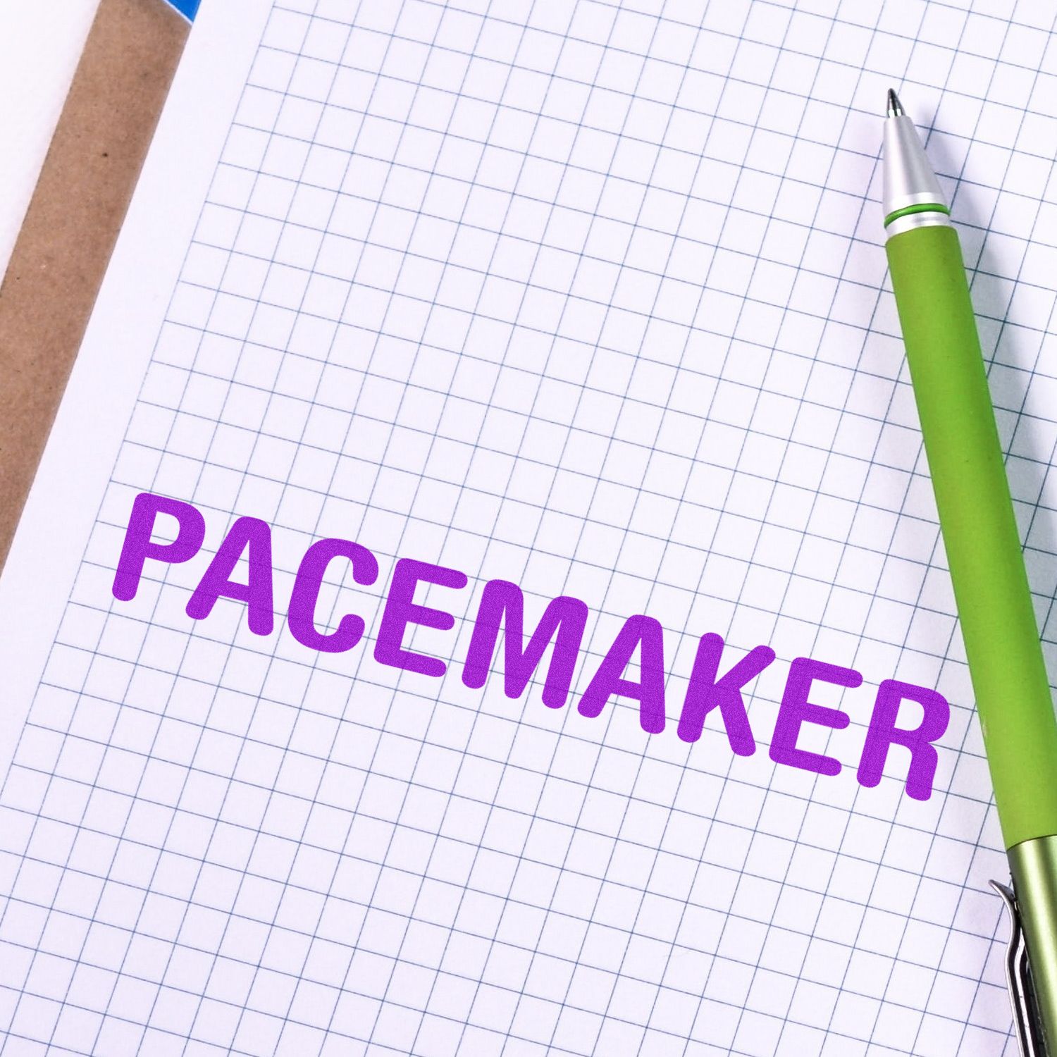 Pacemaker Rubber Stamp in purple ink on graph paper with a green pen beside it.