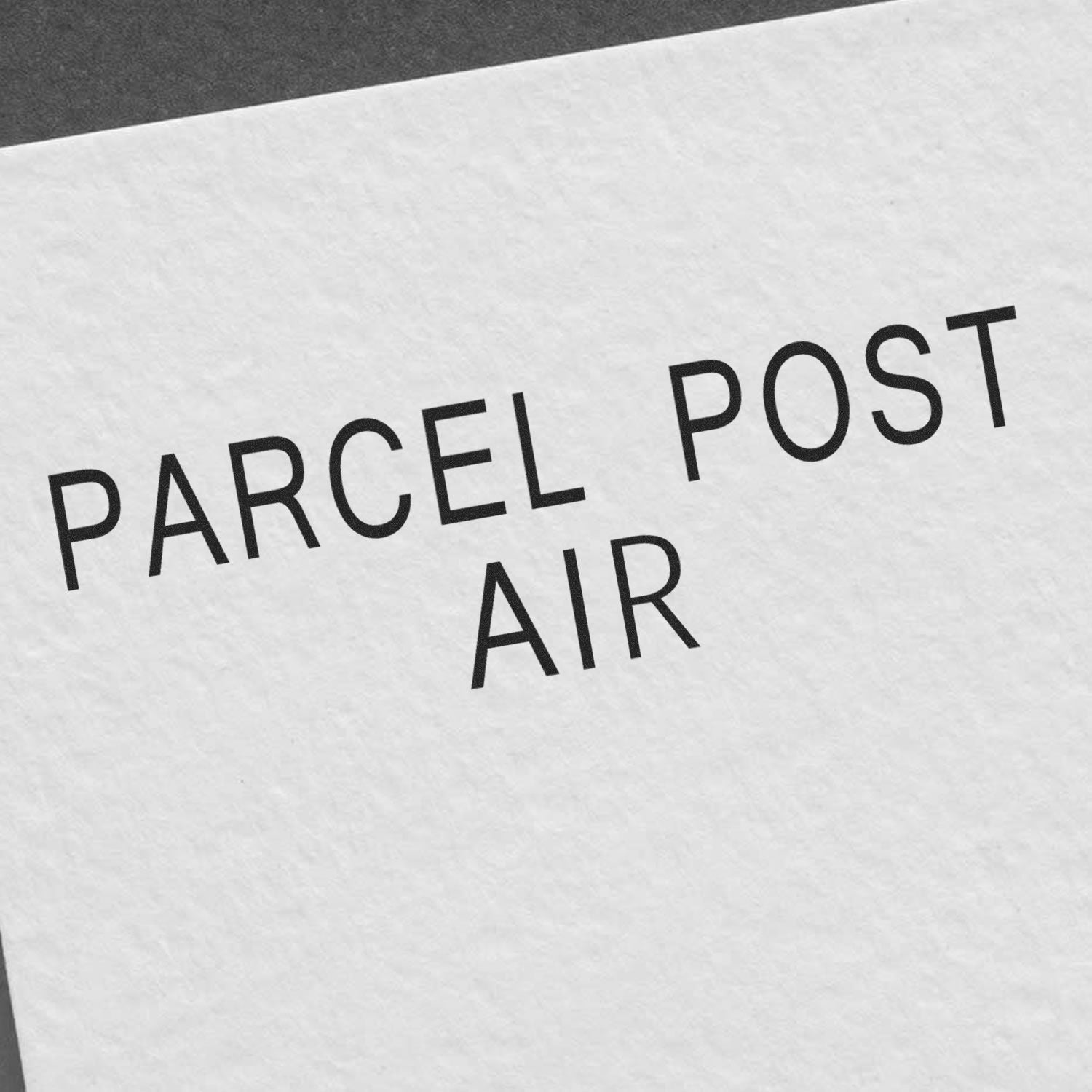 Stamped text 'PARCEL POST AIR' on white paper using the Self Inking Parcel Post Air Stamp.