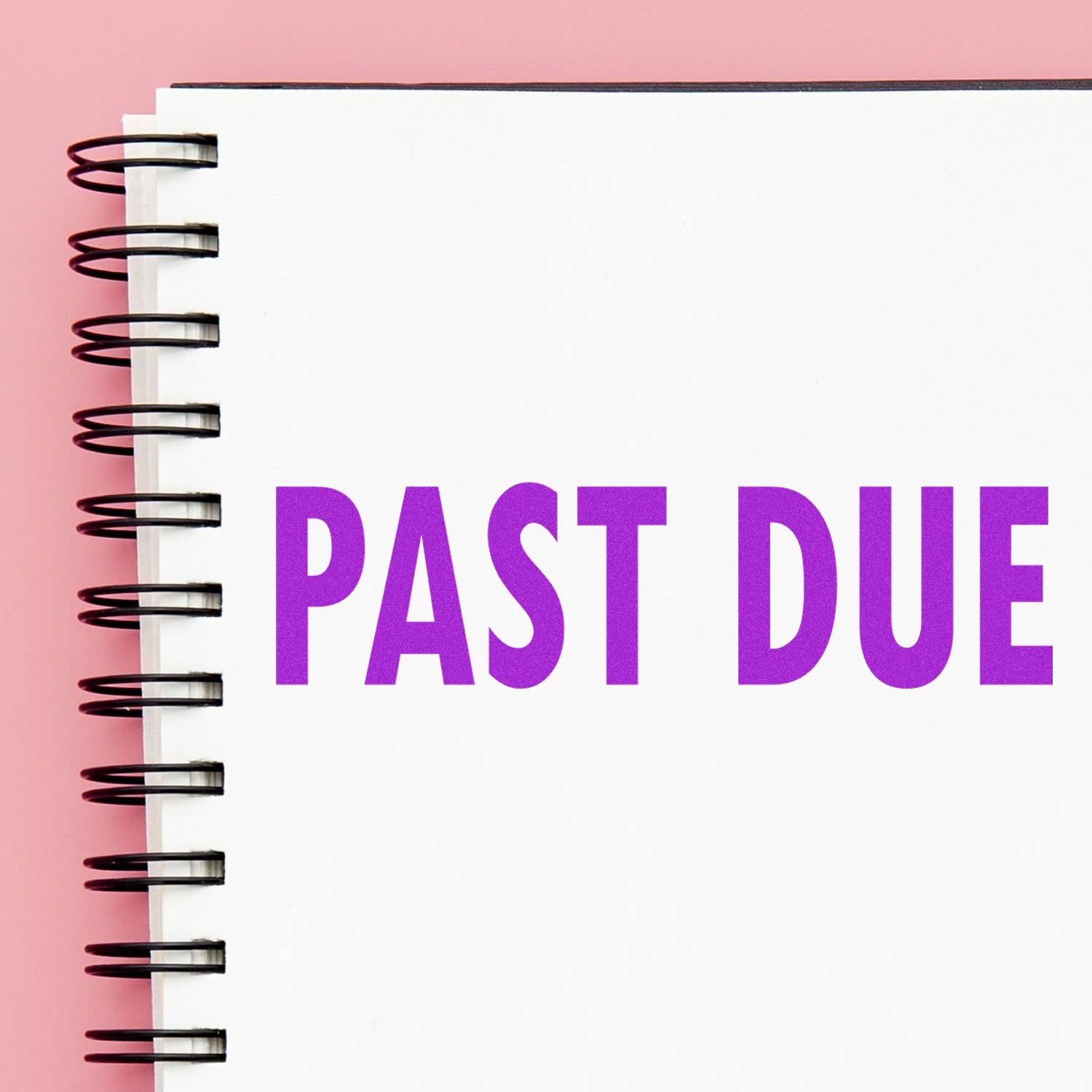 Large Past Due Rubber Stamp in use, marking PAST DUE in bold purple letters on a white spiral notebook against a pink background.