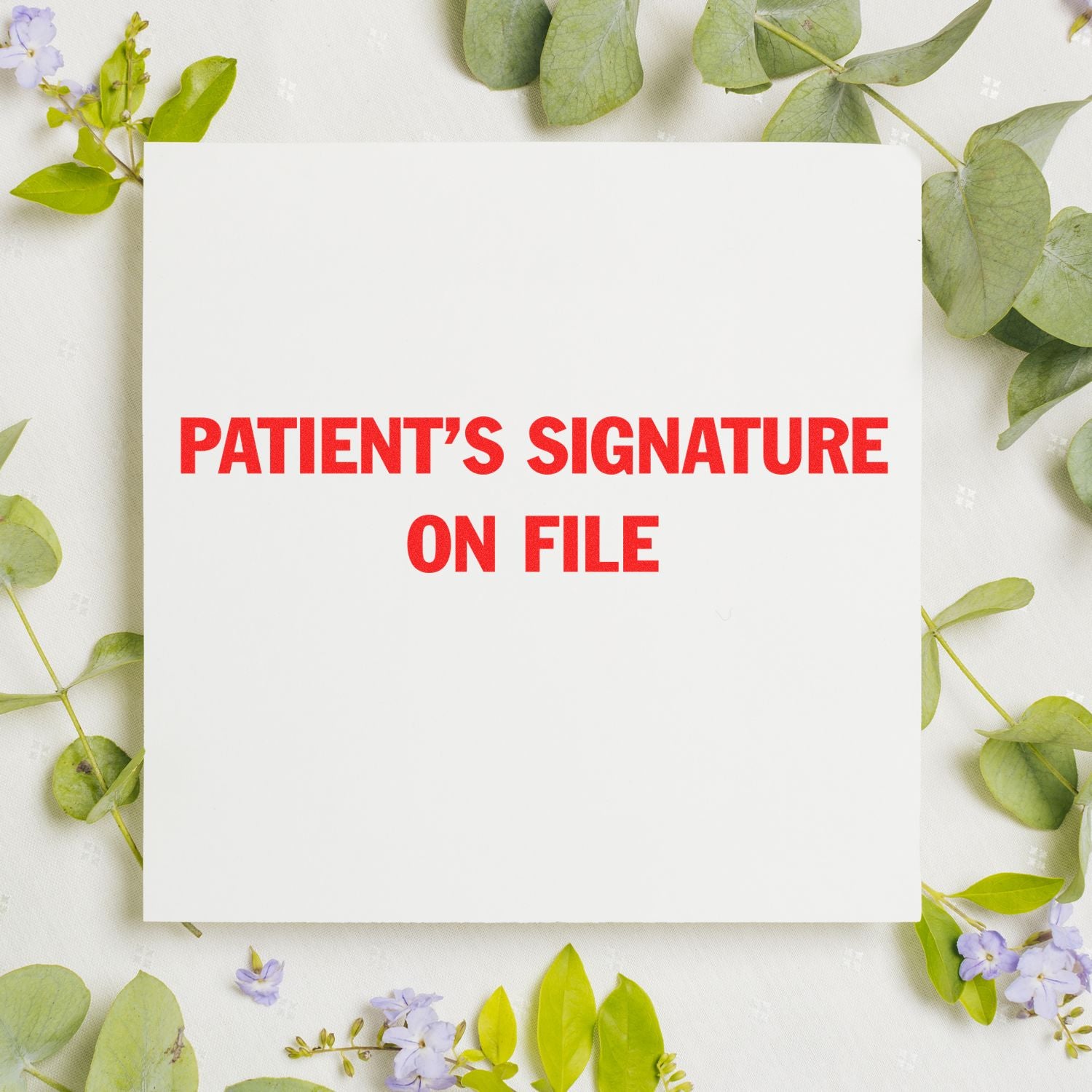 Slim Pre-Inked Patient's Signature on File Stamp in red text on white paper, surrounded by green leaves and small purple flowers.