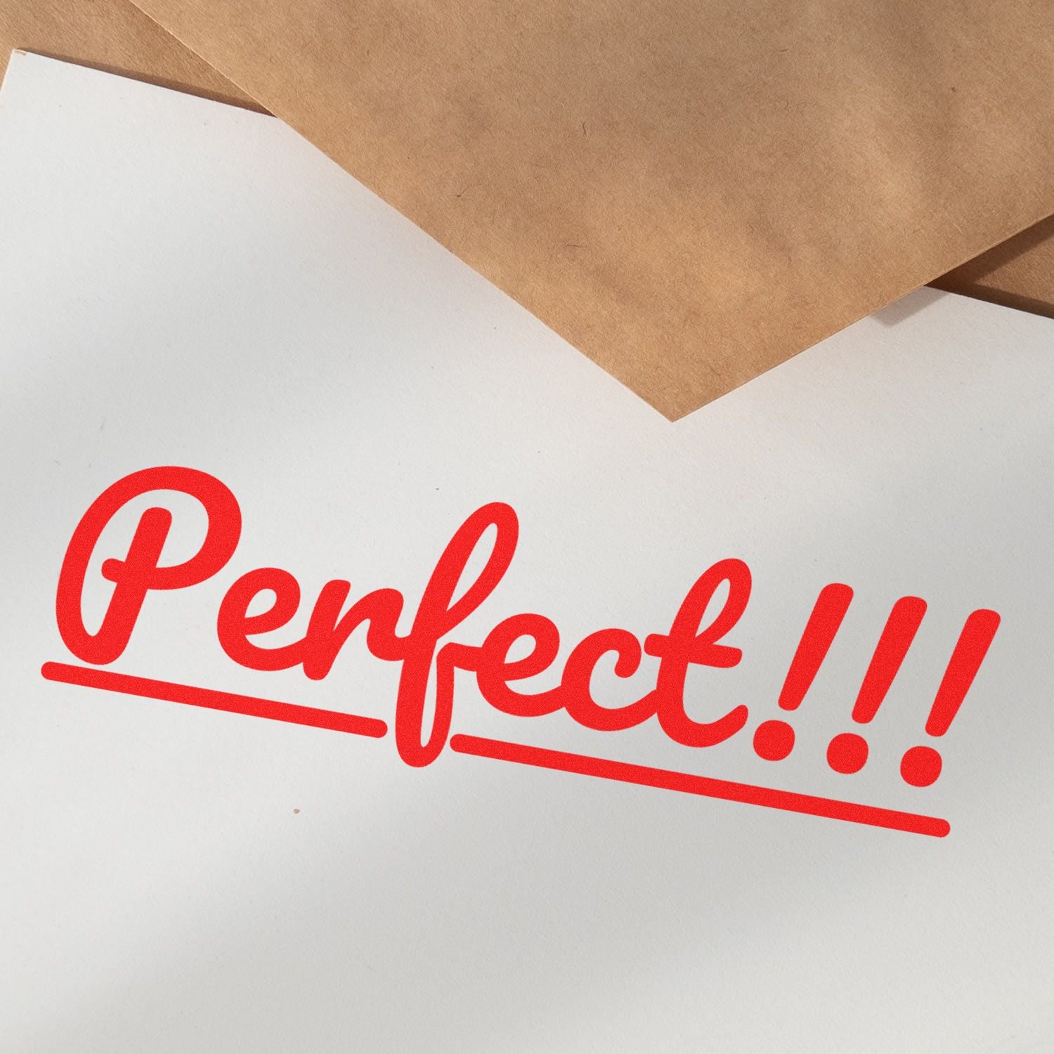 Red 'Perfect!!!' stamped on white paper using Slim Pre-Inked Perfect Stamp, with brown envelopes in the background.