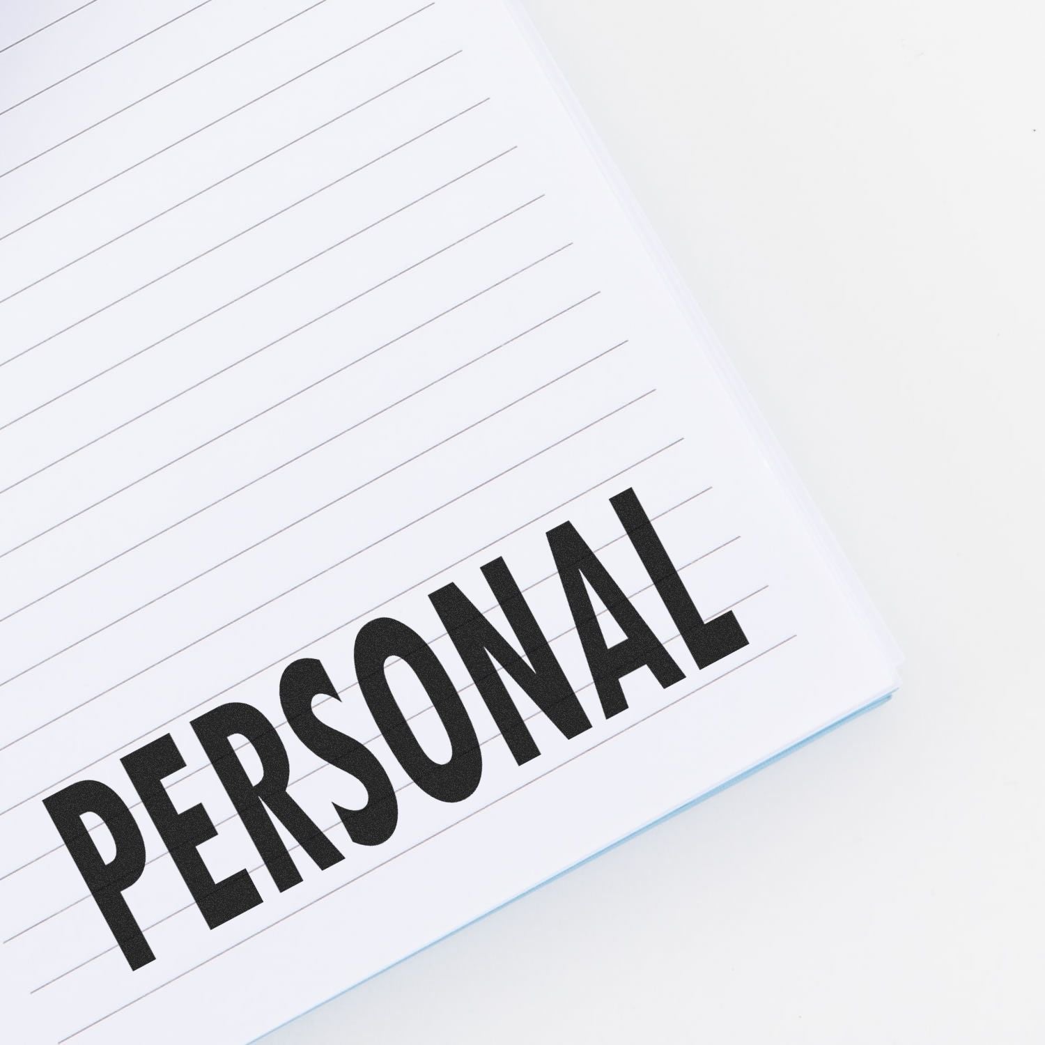 Notebook with 'PERSONAL' stamped in bold letters using a Slim Pre-Inked Personal Stamp on a lined page.