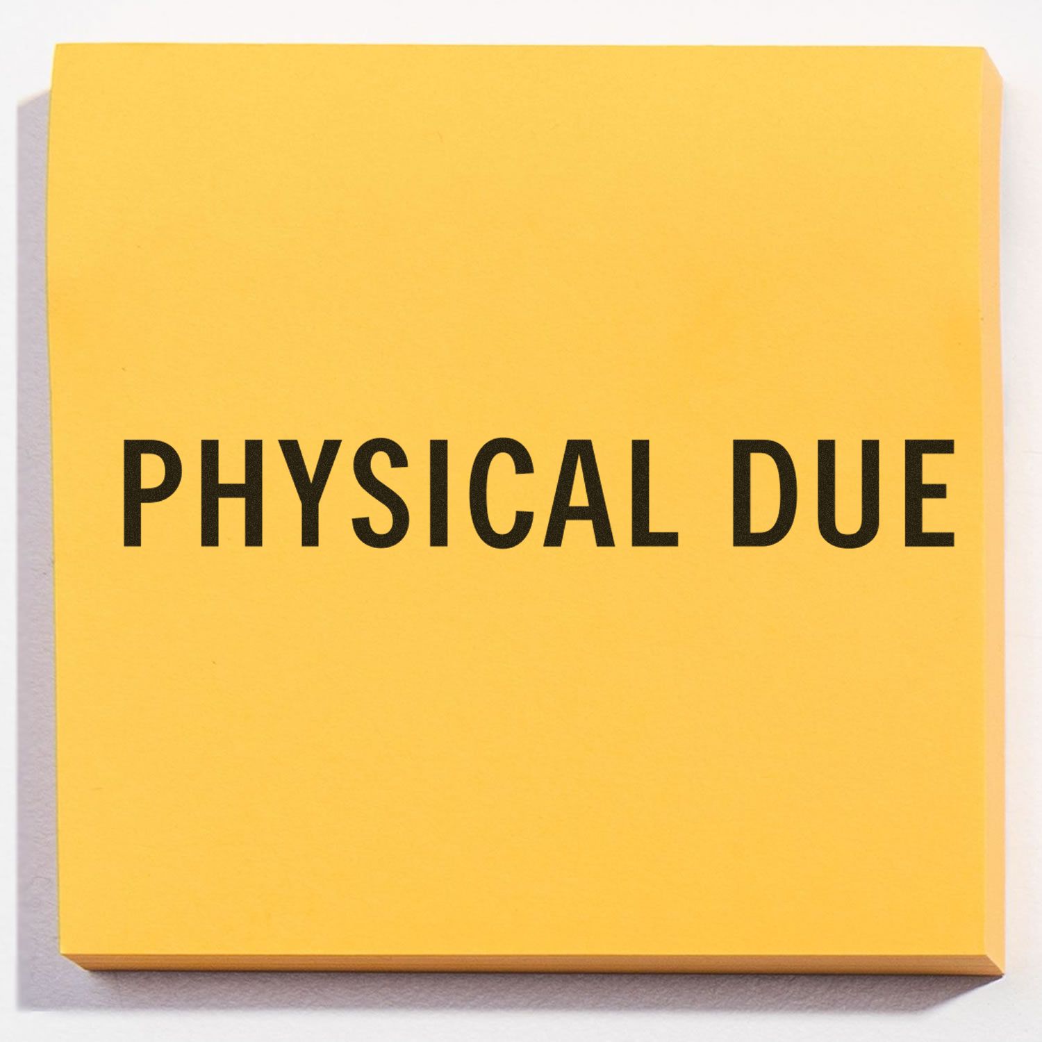 Large Physical Due Rubber Stamp imprint on a yellow sticky note, clearly displaying the text PHYSICAL DUE in bold black letters.