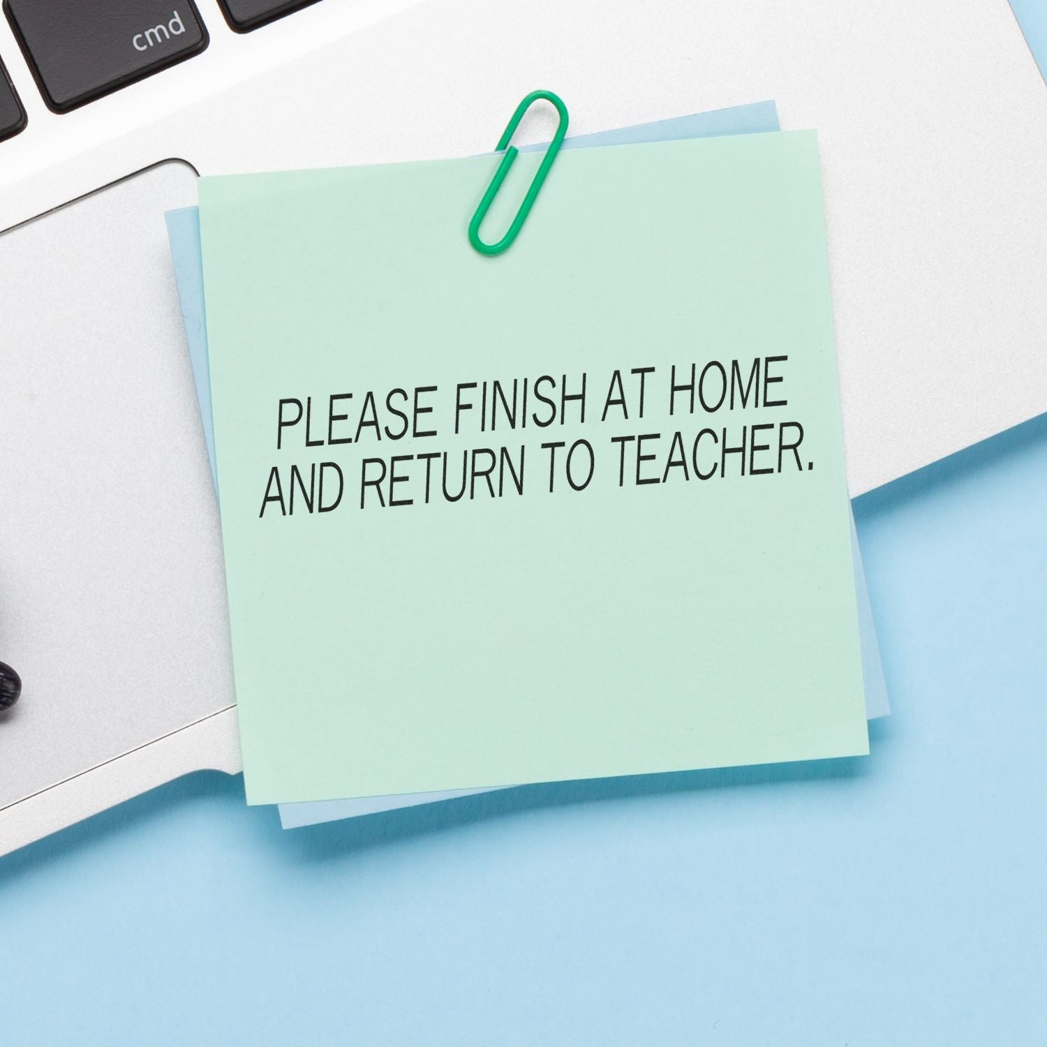 A sticky note stamped with PLEASE FINISH AT HOME AND RETURN TO TEACHER using the Large Self Inking Please Finish At Home And Return To Teacher Stamp.