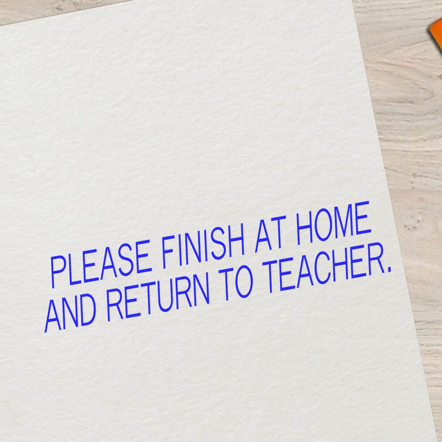 Large Self Inking Please Finish At Home And Return To Teacher Stamp used on white paper, with blue text instructing to finish at home.