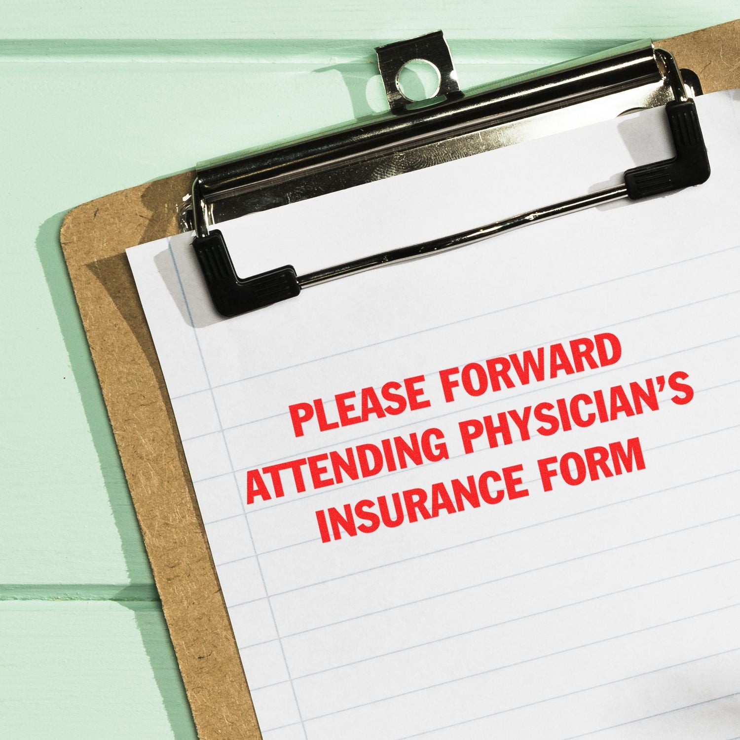 A clipboard with a paper stamped in red ink reading PLEASE FORWARD ATTENDING PHYSICIAN'S INSURANCE FORM on a light green background.