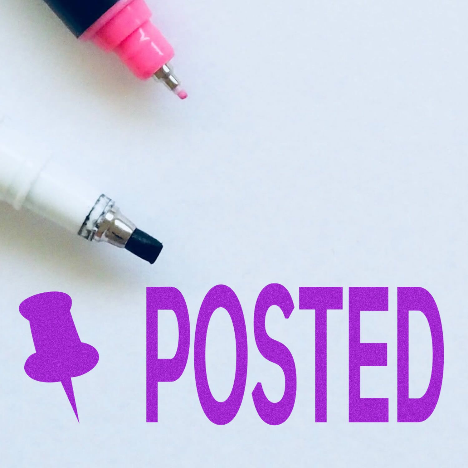 Posted with Thumbtack rubber stamp in purple next to two markers, one pink and one white, on a white background.