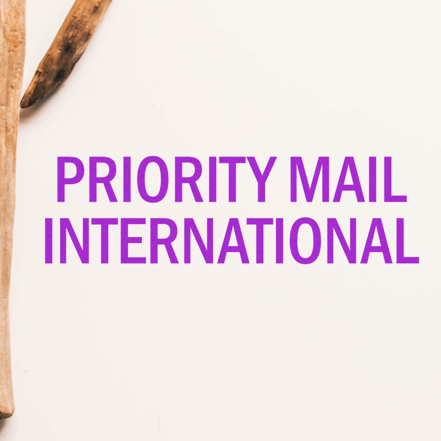 Self Inking Priority Mail International Stamp in purple ink on a white background with wooden sticks partially visible on the left side.