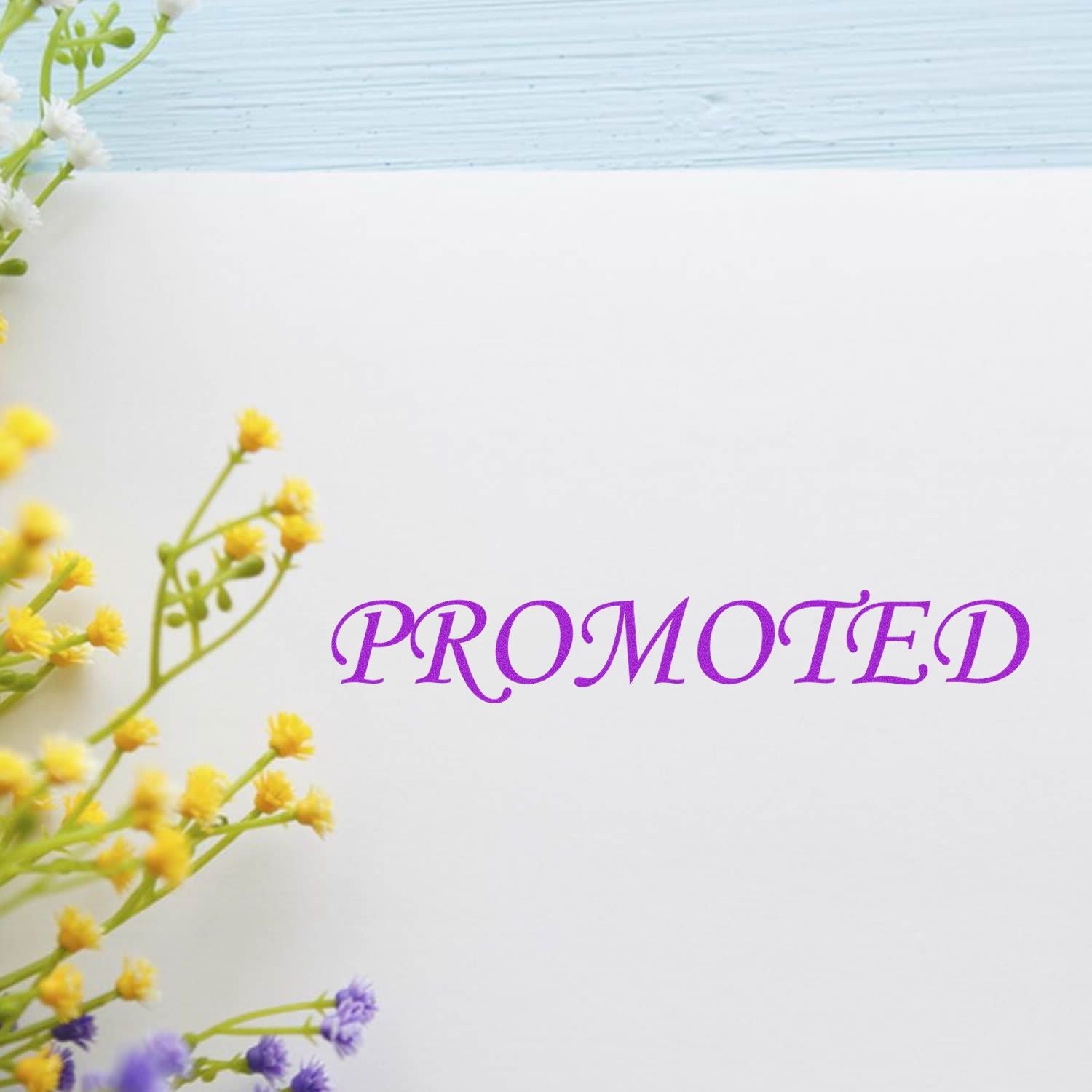 Self Inking Promoted Stamp in purple ink on white paper, surrounded by yellow and purple flowers.