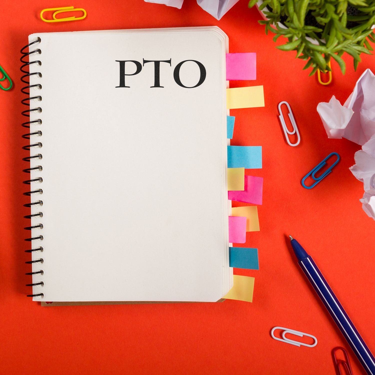 Notebook stamped with PTO using Large Self Inking PTO Stamp, surrounded by colorful sticky notes, paperclips, and a pen on a red background.