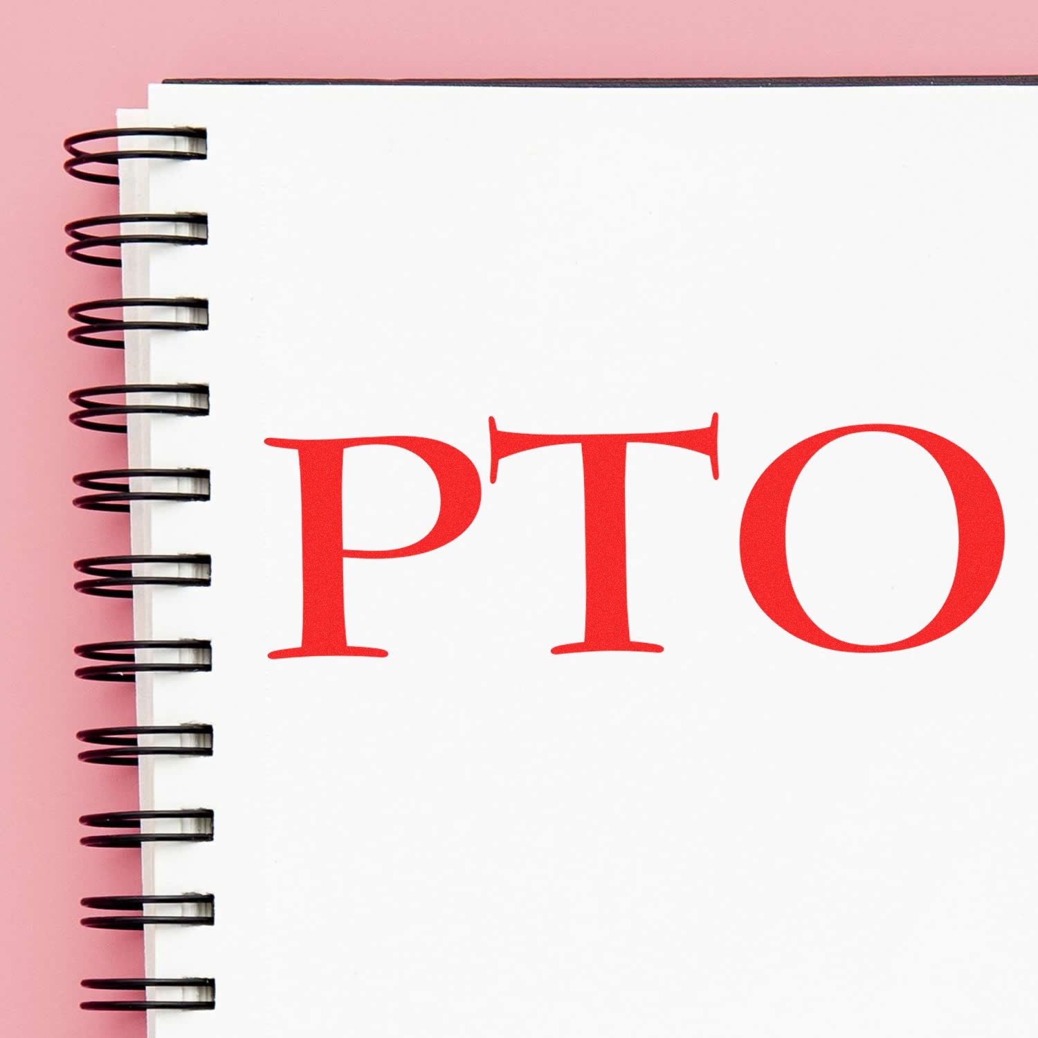 Large PTO Rubber Stamp in red ink on a white spiral notebook with a pink background.