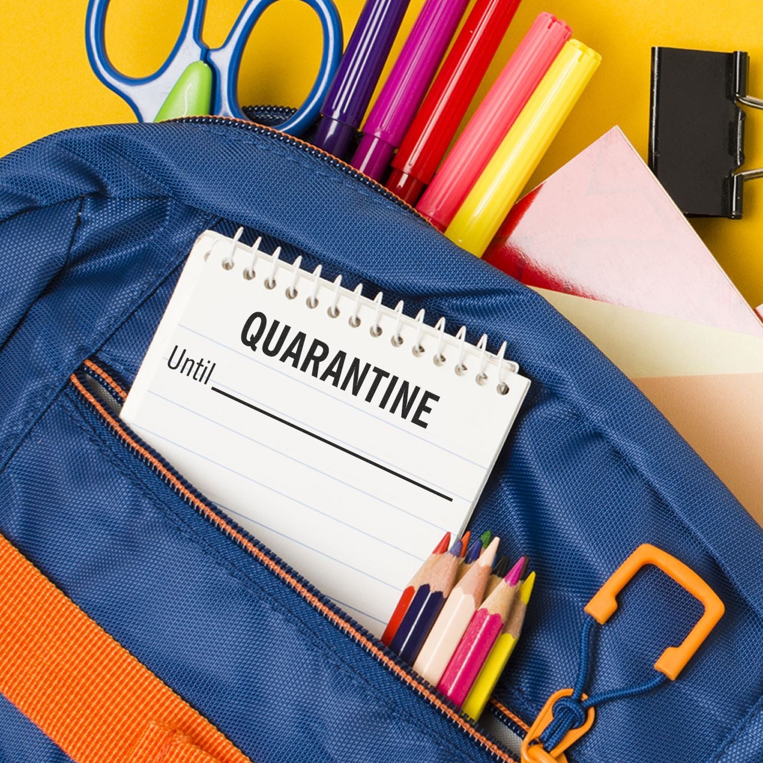 A Quarantine Until rubber stamp on a notepad inside a blue backpack with colorful stationery items around it.