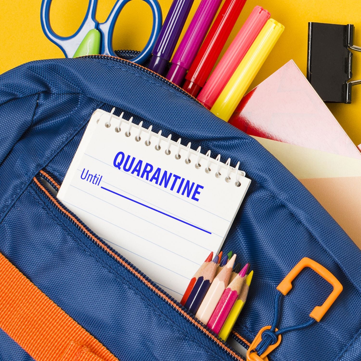 A Slim Pre-Inked Quarantine Until Stamp on a notepad inside a blue backpack with colorful stationery items.