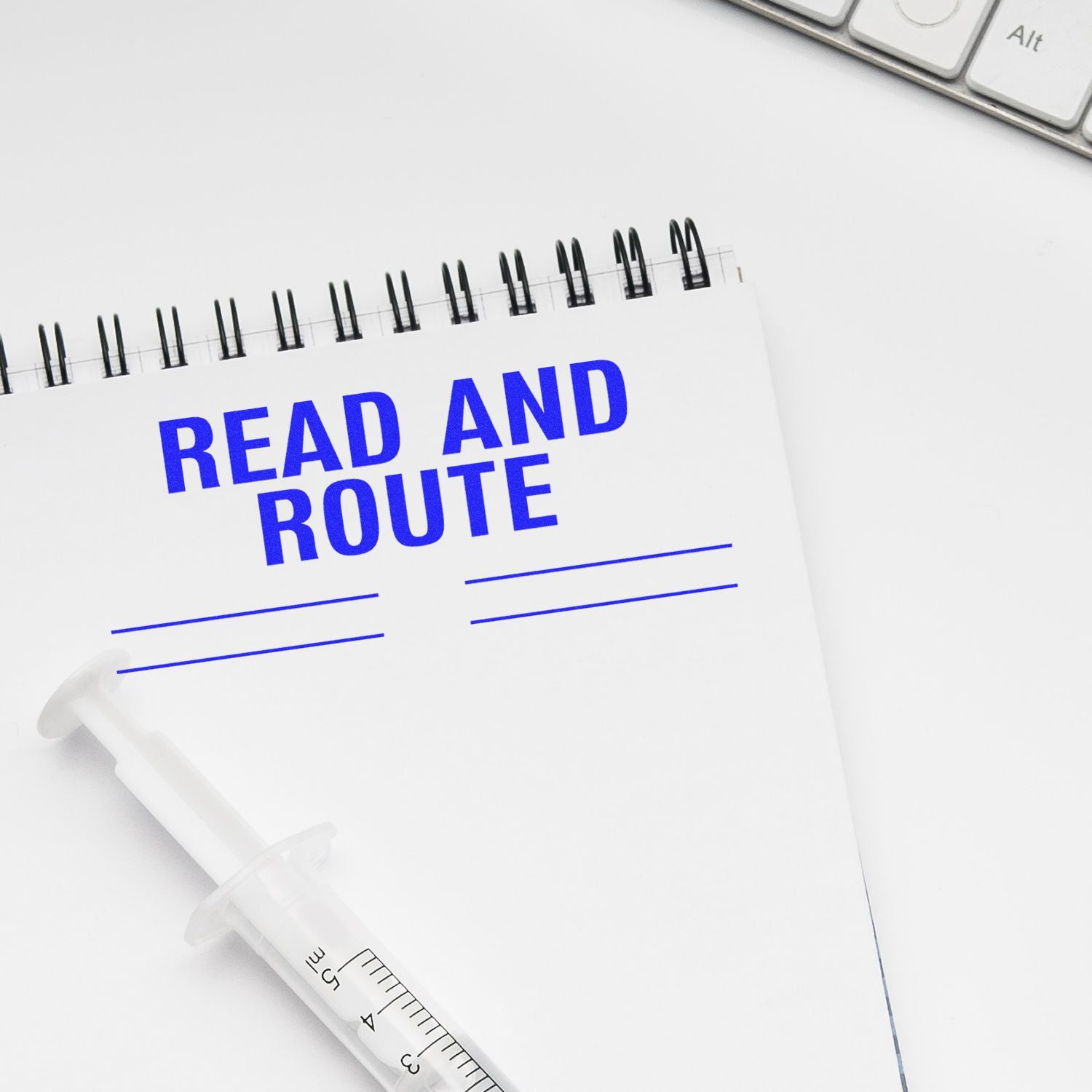 Read and Route with Lines rubber stamp impression on a white notepad with a syringe and keyboard in the background.