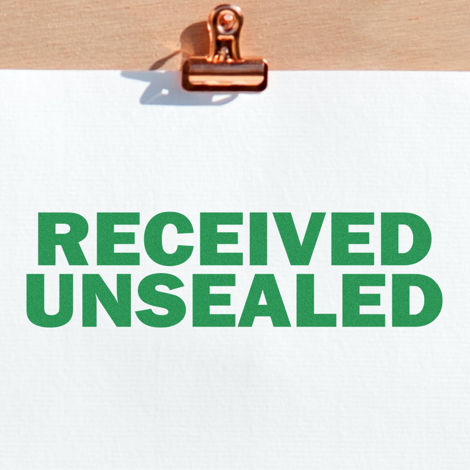 Large Received Unsealed Rubber Stamp in green ink on white paper, clipped to a wooden board with a metal clip.