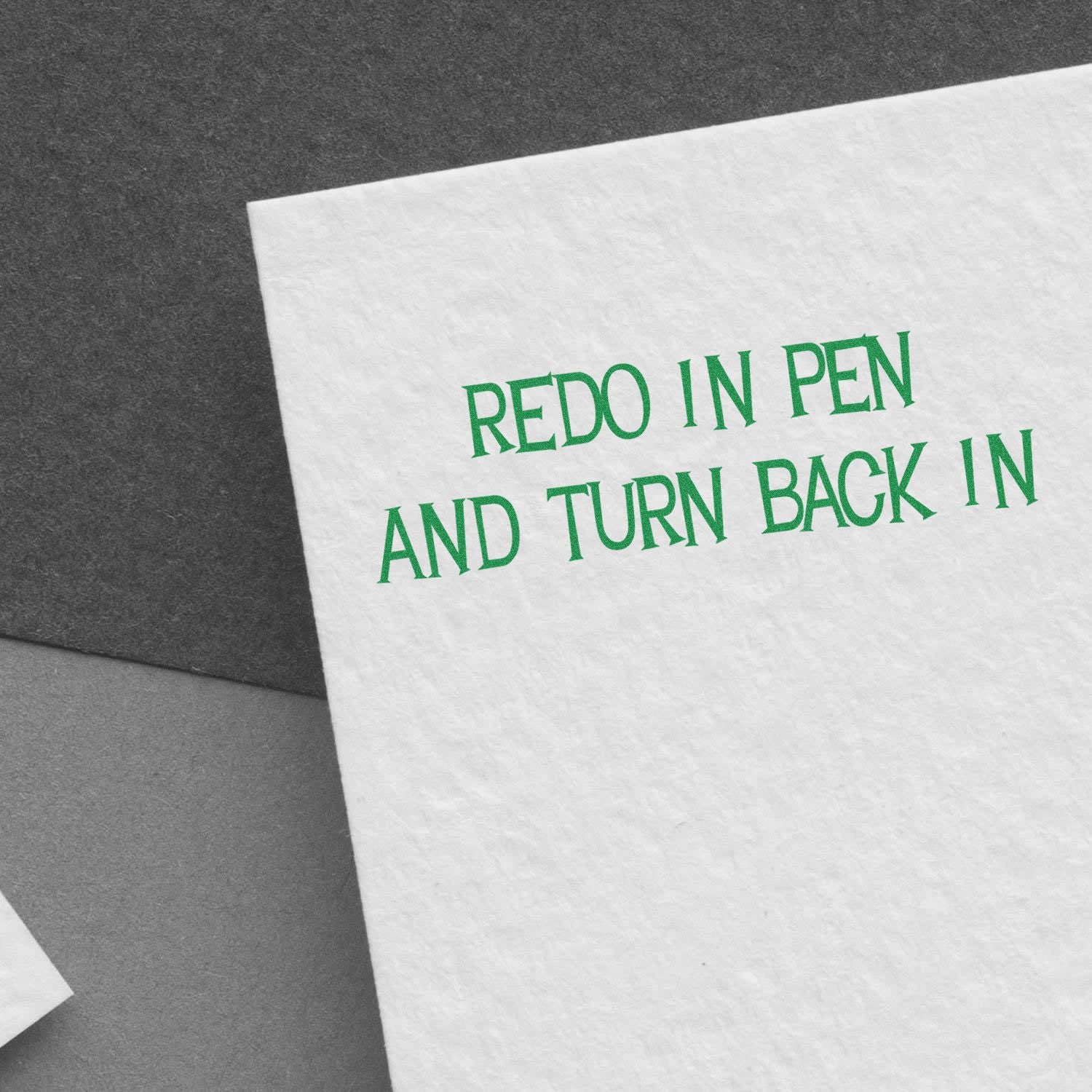 Large Self Inking Redo In Pen And Turn Back In Stamp in use, stamping green text on white paper against a dark background.