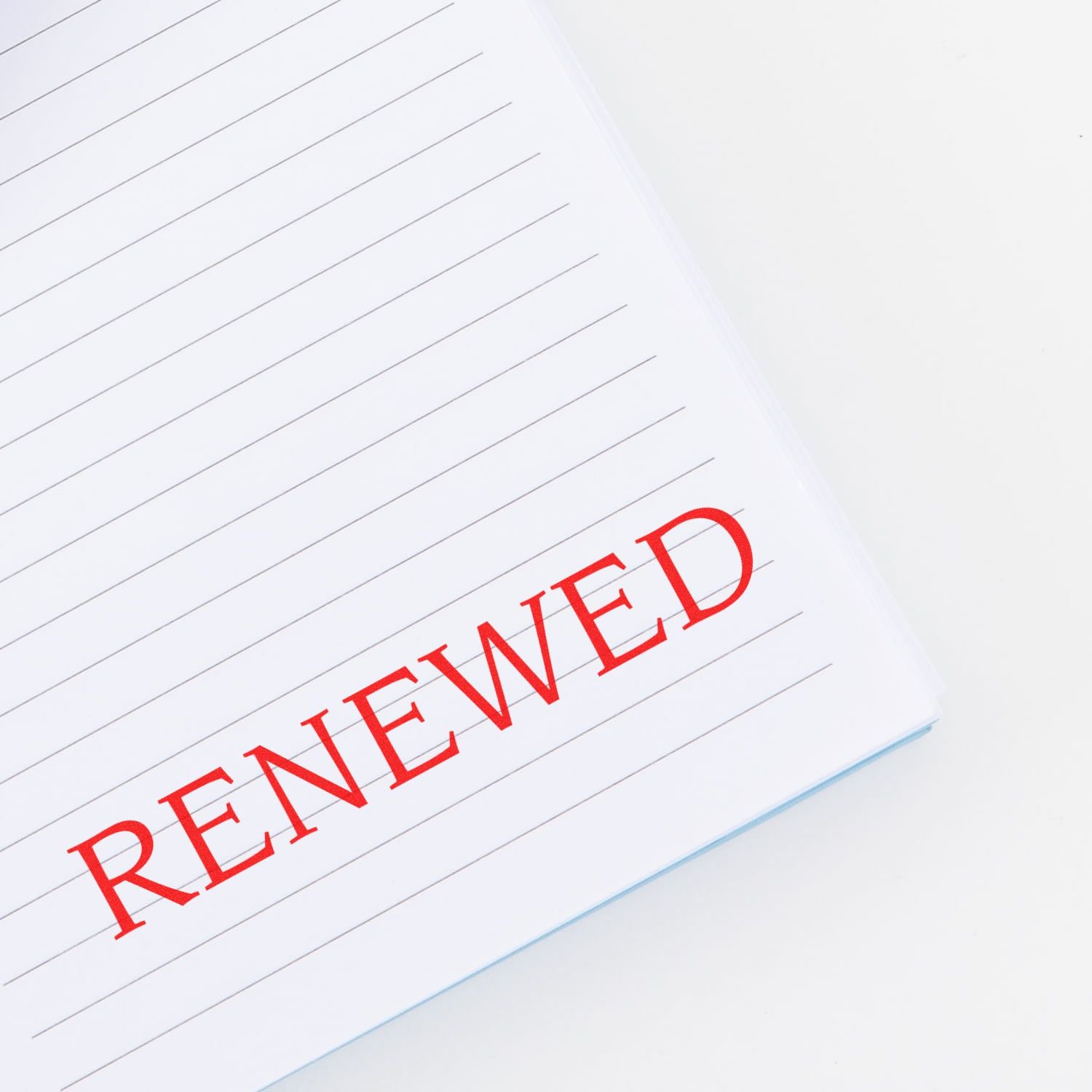 Large Self Inking Renewed Stamp in red ink on a lined white notebook page, showing the word RENEWED clearly stamped.