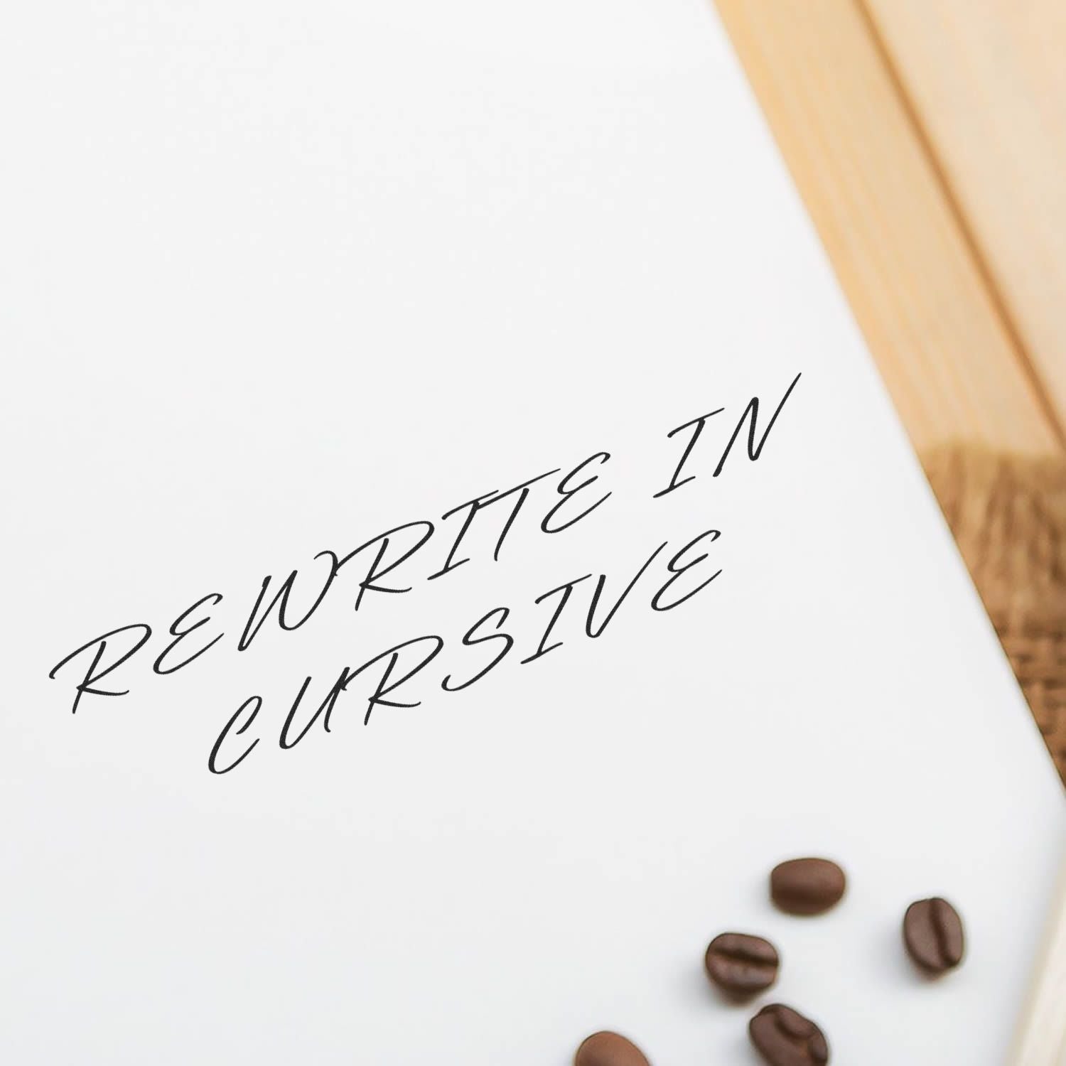 Large Self Inking Rewrite In Cursive Stamp imprint on white paper with coffee beans on a wooden surface in the background.