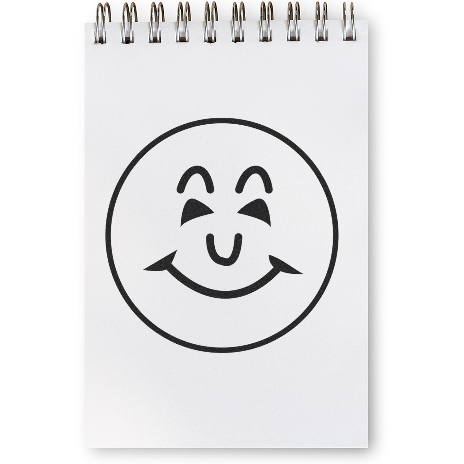 Round Happy Face Rubber Stamp impression on a white spiral notebook page, showing a smiling face with closed eyes.