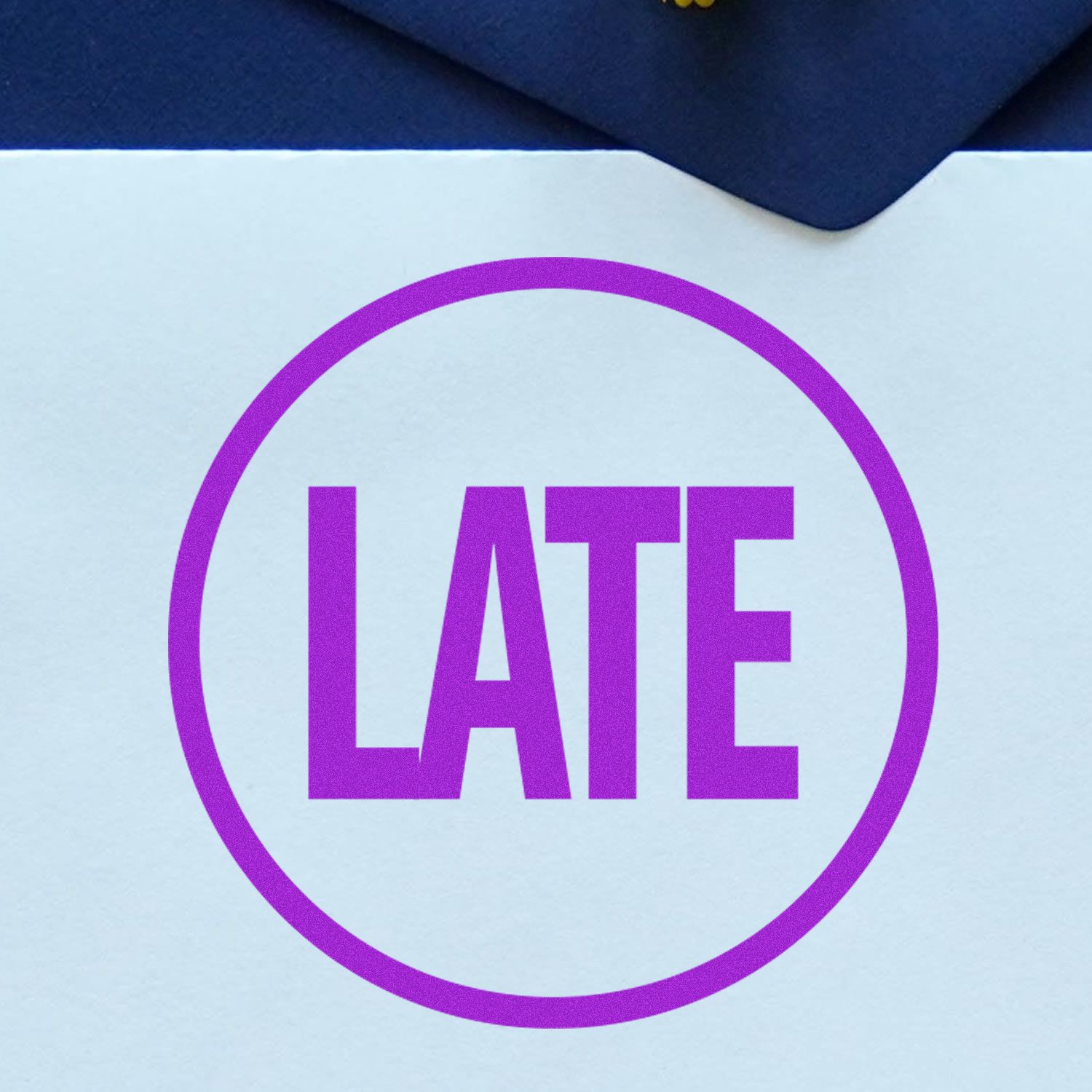 Round Late Rubber Stamp in purple ink on a white paper, partially covered by a dark blue envelope.