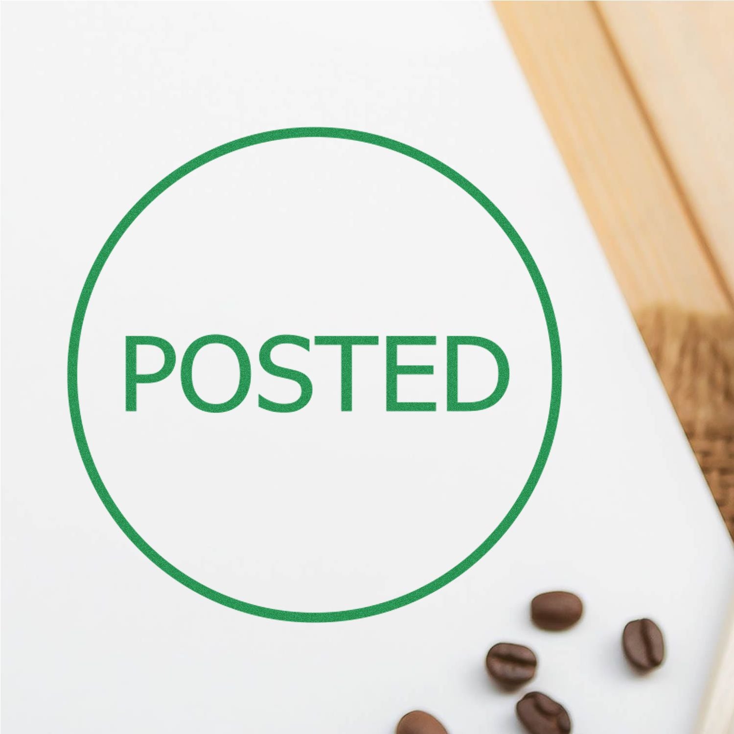 Round Posted Rubber Stamp in green ink on white paper, with coffee beans scattered nearby on a wooden surface.