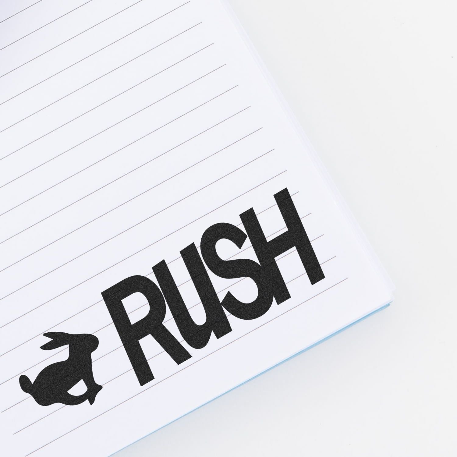 Slim Pre-Inked Rush with Rabbit Stamp used on a lined notebook, showing a black rabbit icon next to the word RUSH .