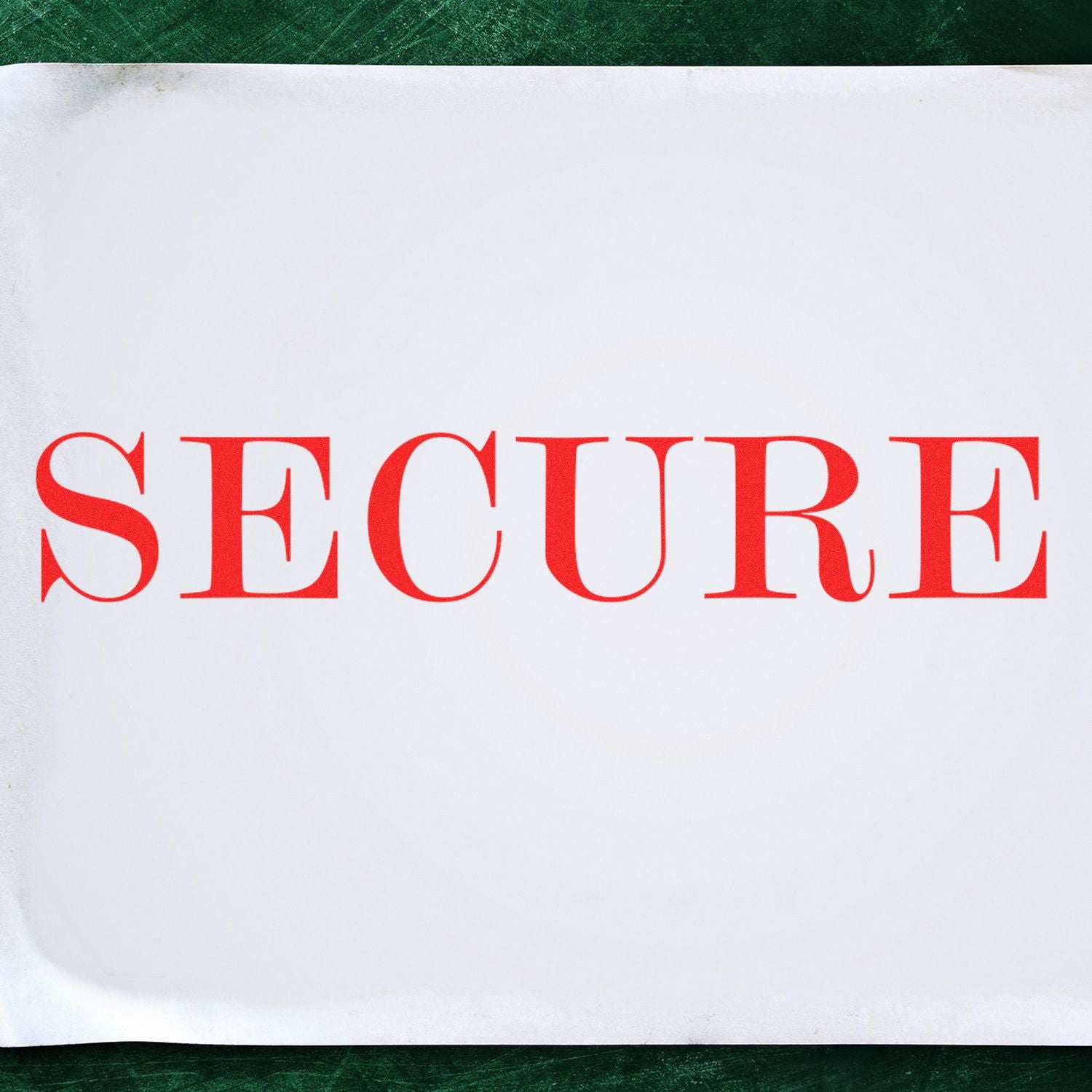 Paper stamped with the word SECURE in red ink using the Self Inking Secure Stamp, placed on a green surface.