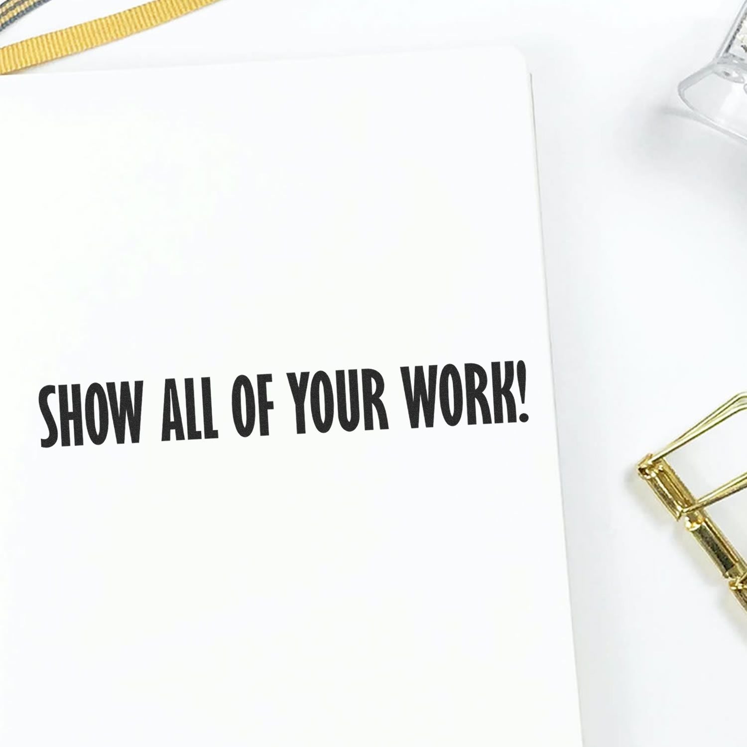 Slim Pre-Inked Show All Of Your Work Stamp imprint on white paper, with a gold paperclip and a yellow ribbon nearby.