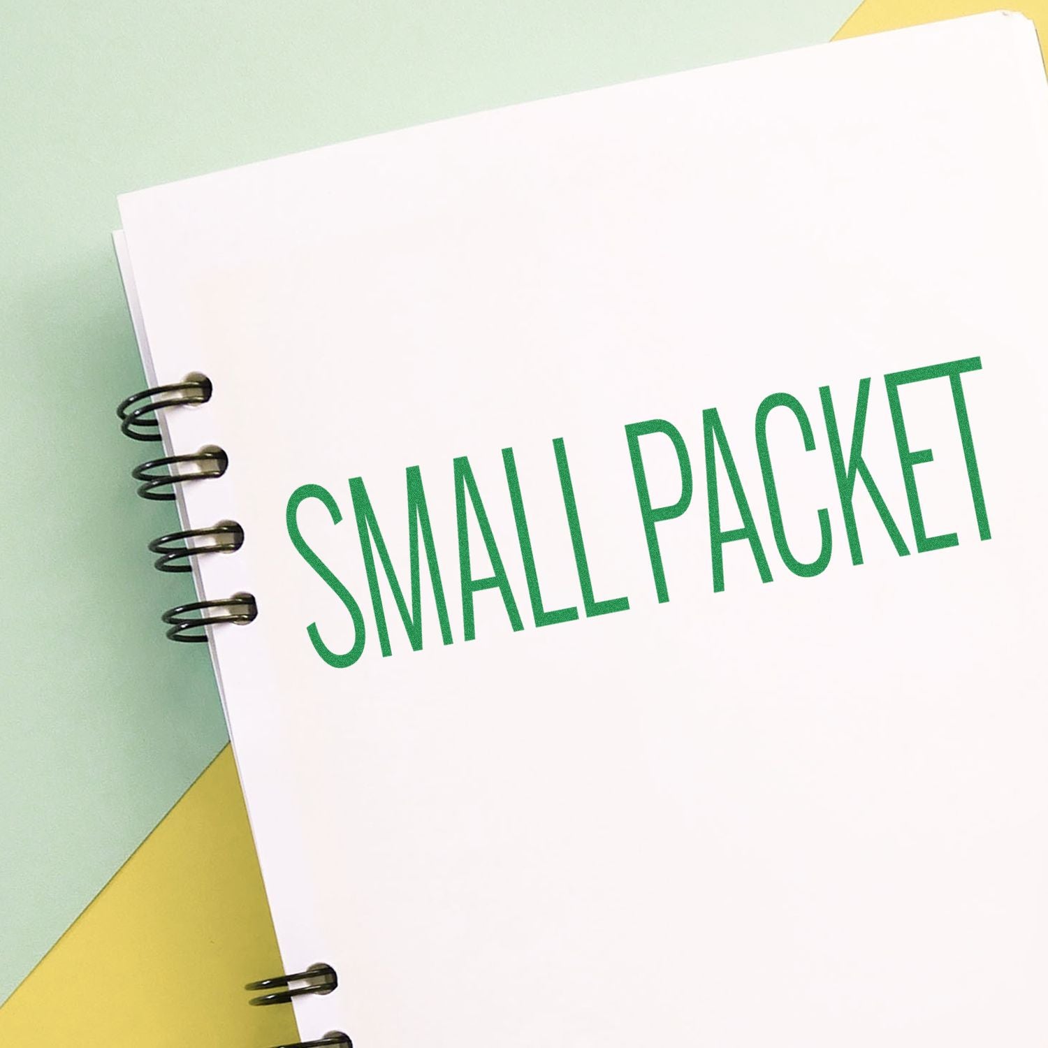 Notebook with 'Small Packet' stamped in green using a small packet rubber stamp on a pastel background.