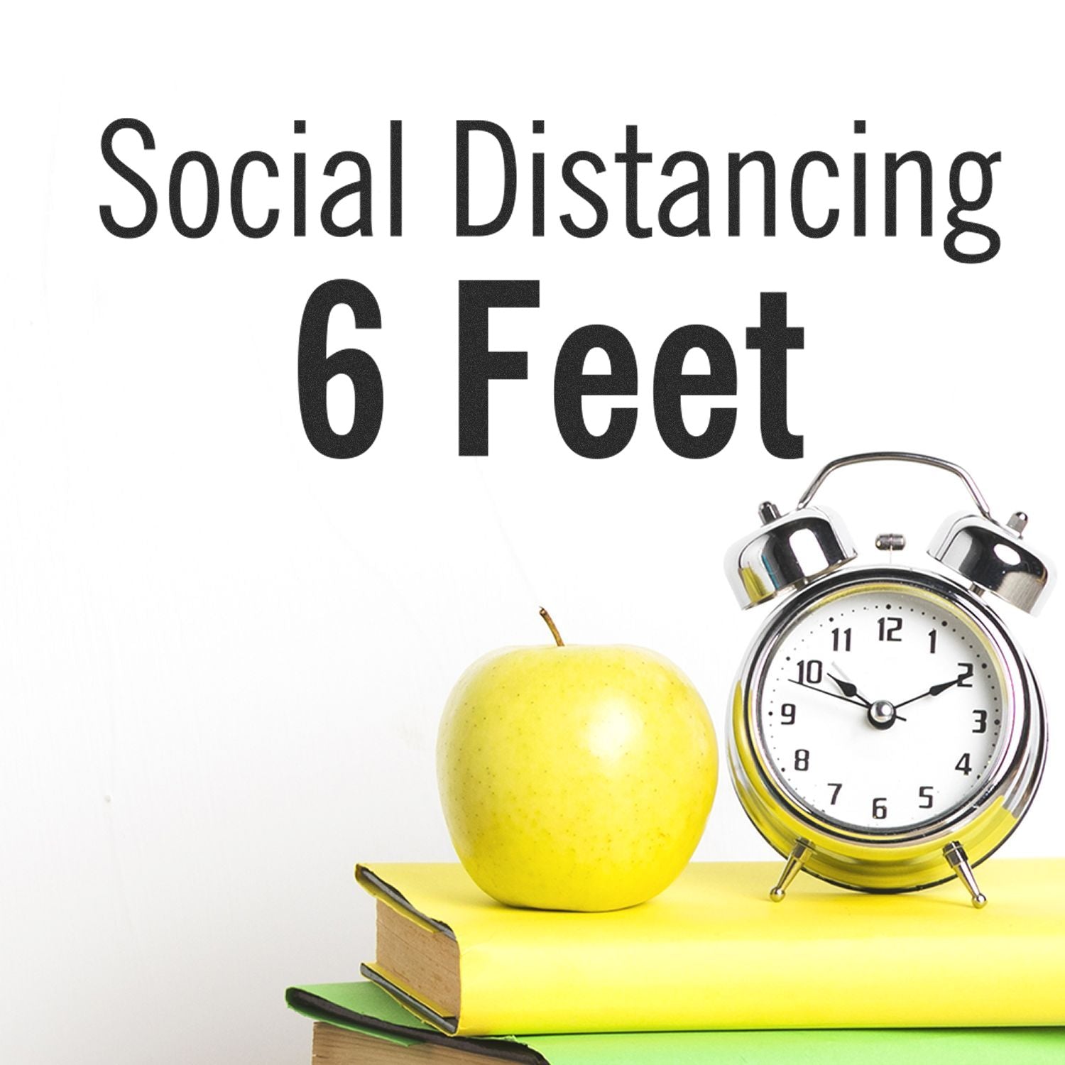 Self Inking Social Distancing 6 Feet Stamp on a desk with a clock, apple, and books, emphasizing the importance of maintaining distance.