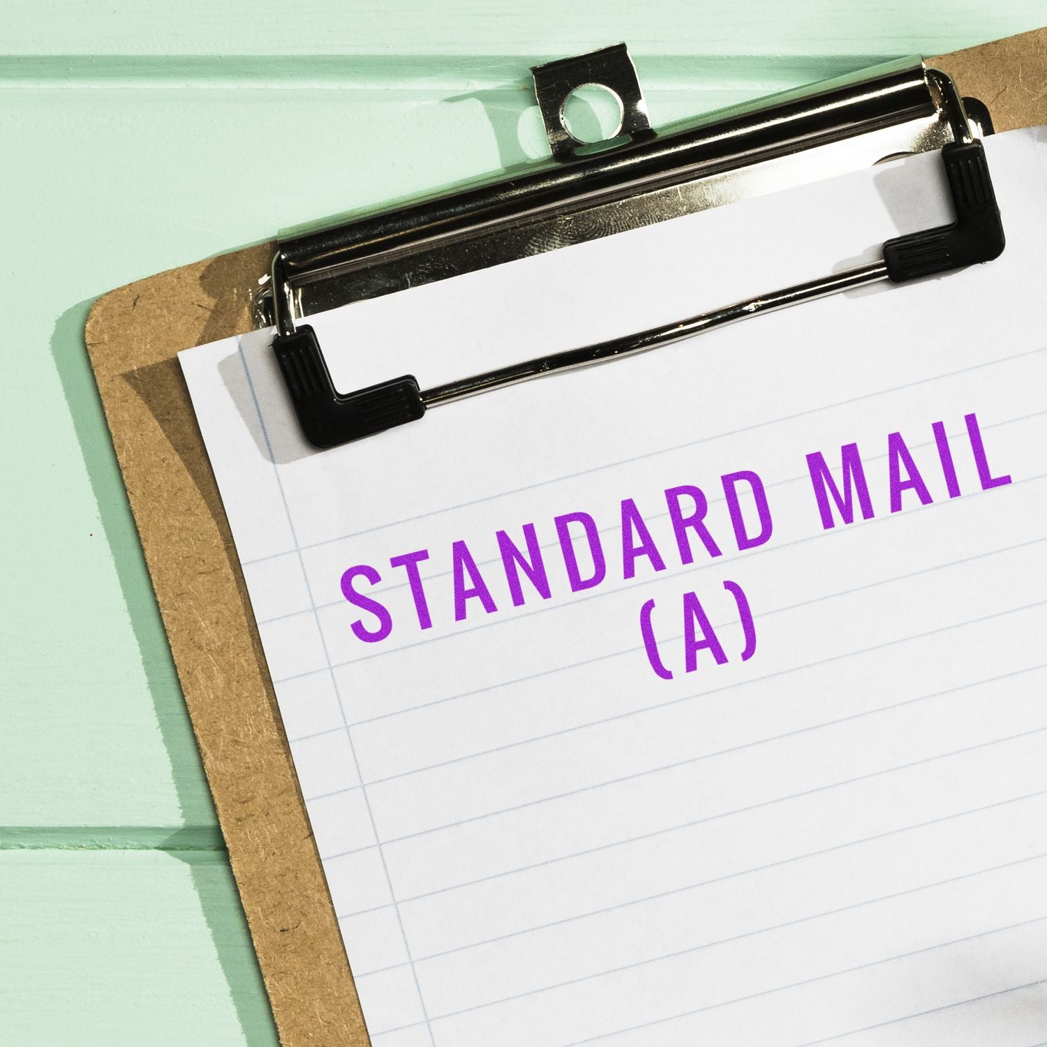 Clipboard with paper stamped STANDARD MAIL (A) in purple ink using the Large Self Inking Standard Mail (A) Stamp.