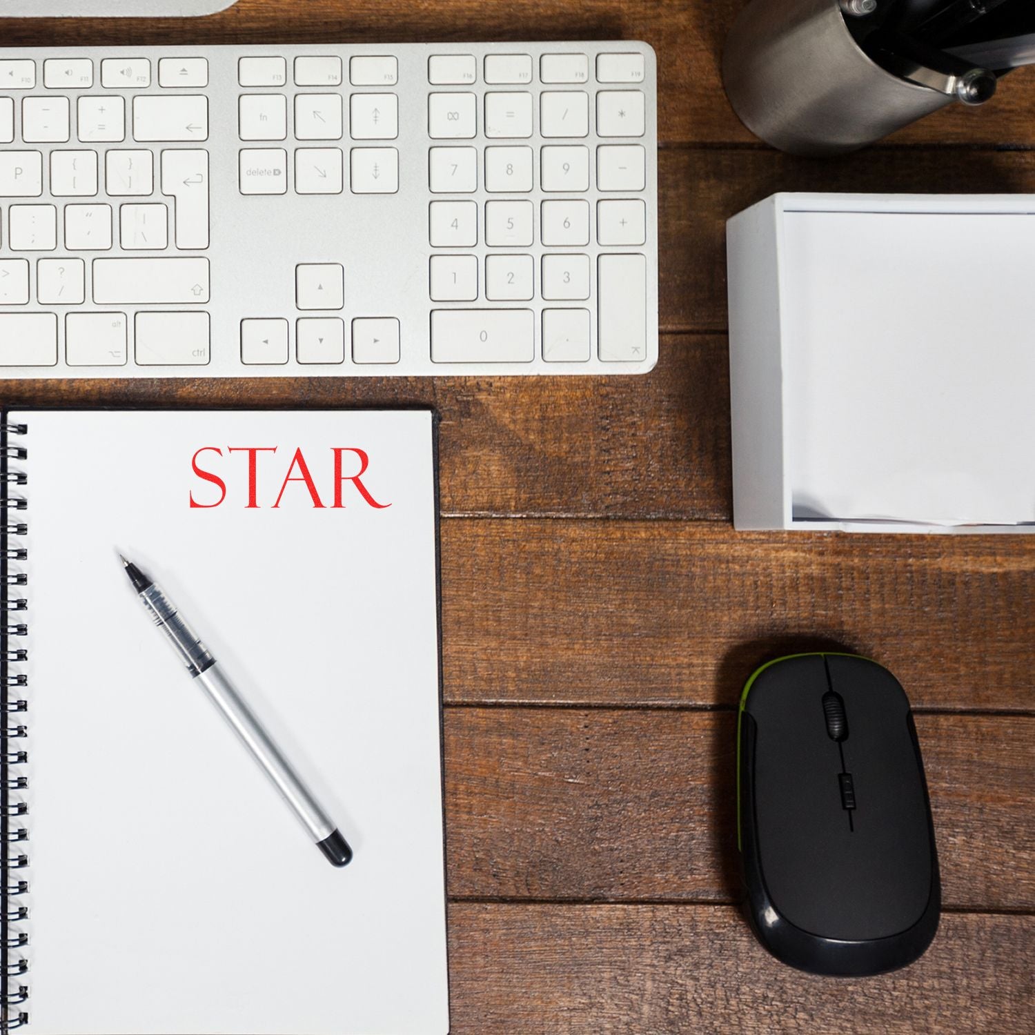 Large Self Inking Star Stamp used on a notebook with a pen, keyboard, mouse, and other office supplies on a wooden desk.