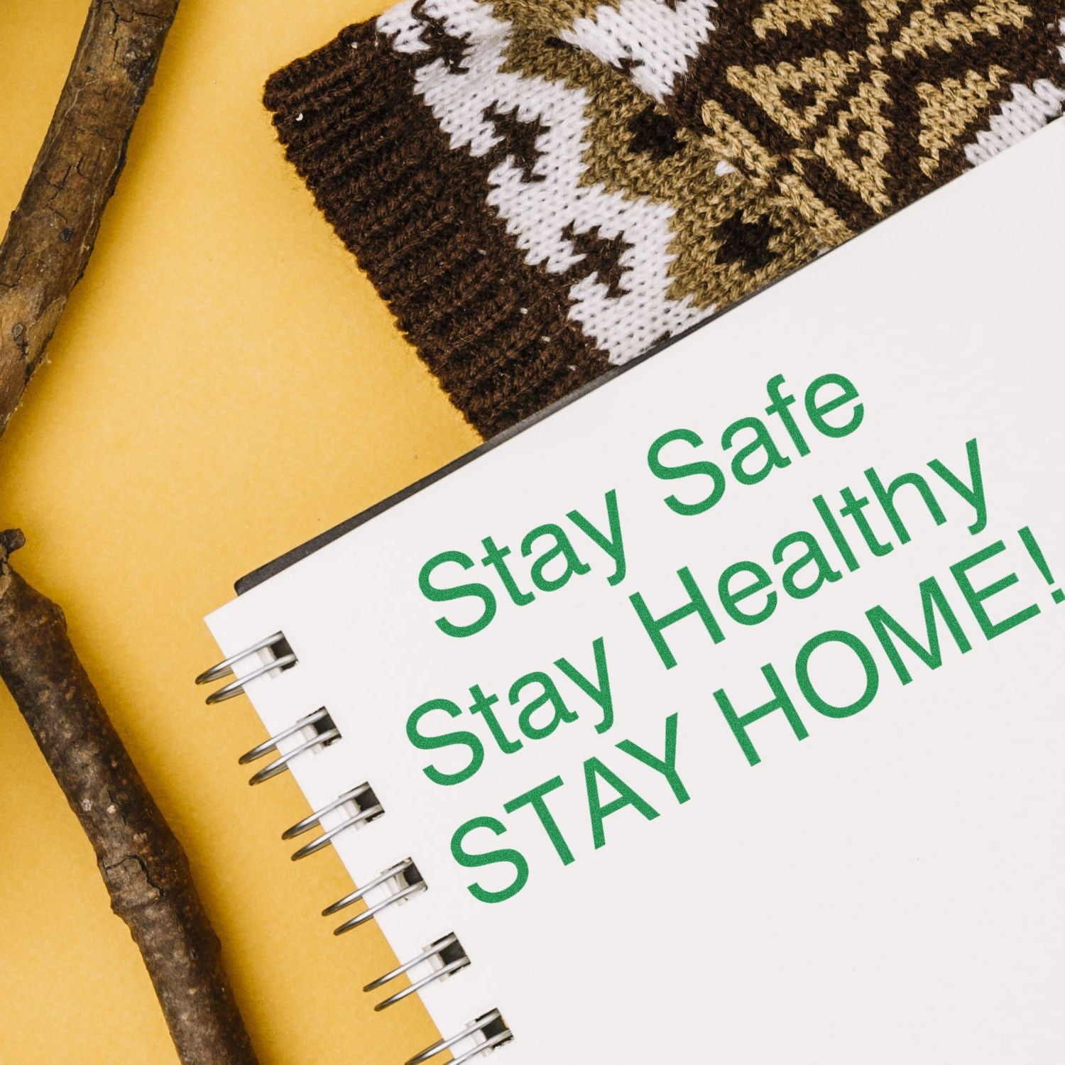 Large Self Inking Stay Safe Stay Healthy Stamp used on a spiral notebook with the message Stay Safe Stay Healthy STAY HOME! next to a knitted item.