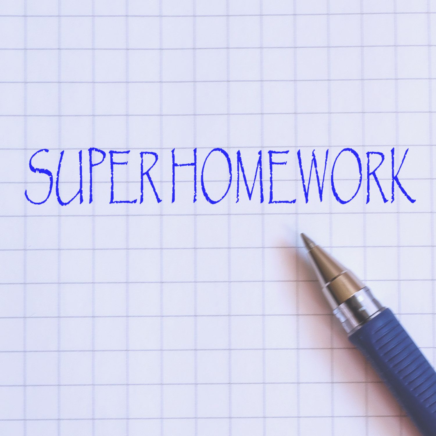 A blue pen next to a stamped "SUPER HOMEWORK" text on graph paper, showcasing the Super Homework Rubber Stamp in use.