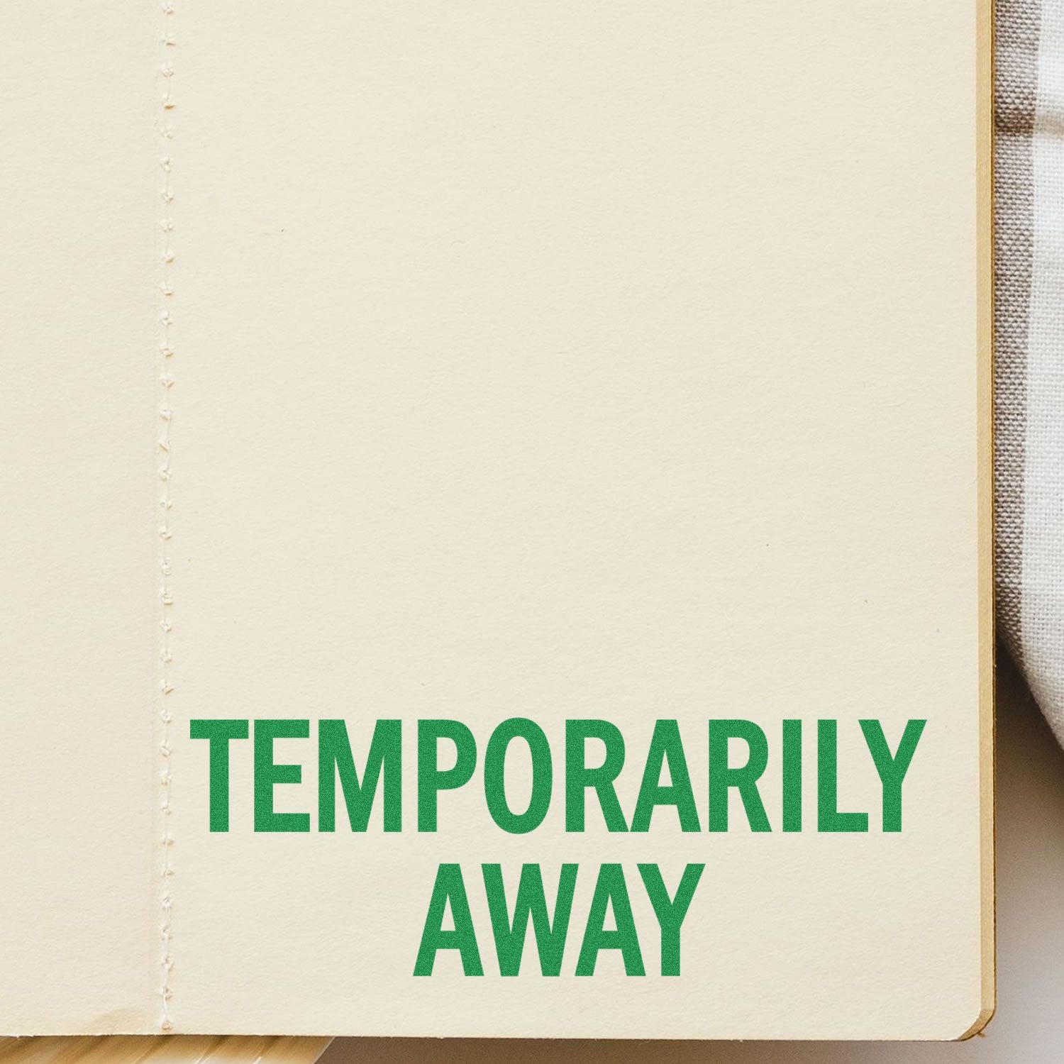 Green 'Temporarily Away' text stamped on a beige page using the Self Inking Temporarily Away Stamp.