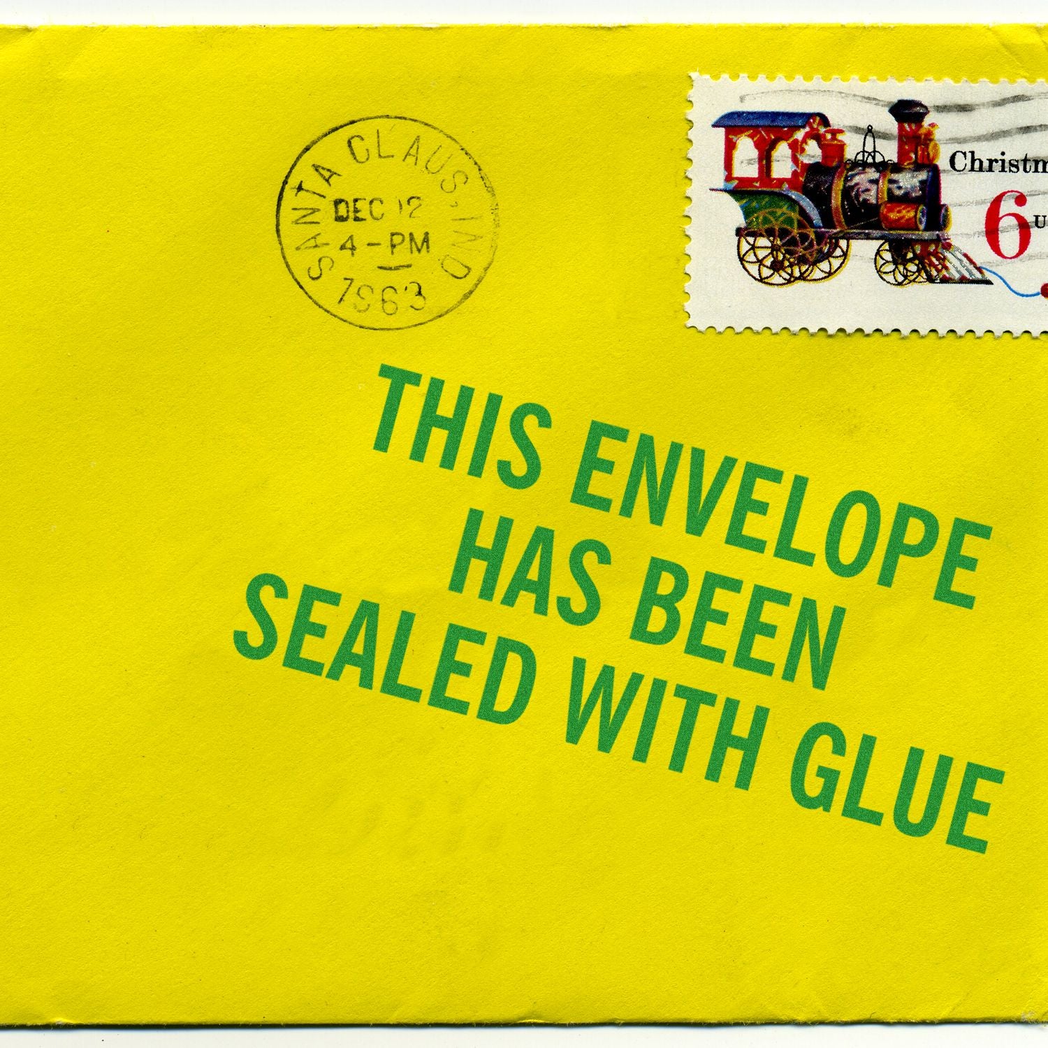 Yellow envelope with a Santa Claus postmark and a Christmas stamp, stamped with This Envelope Has Been Sealed With Glue.