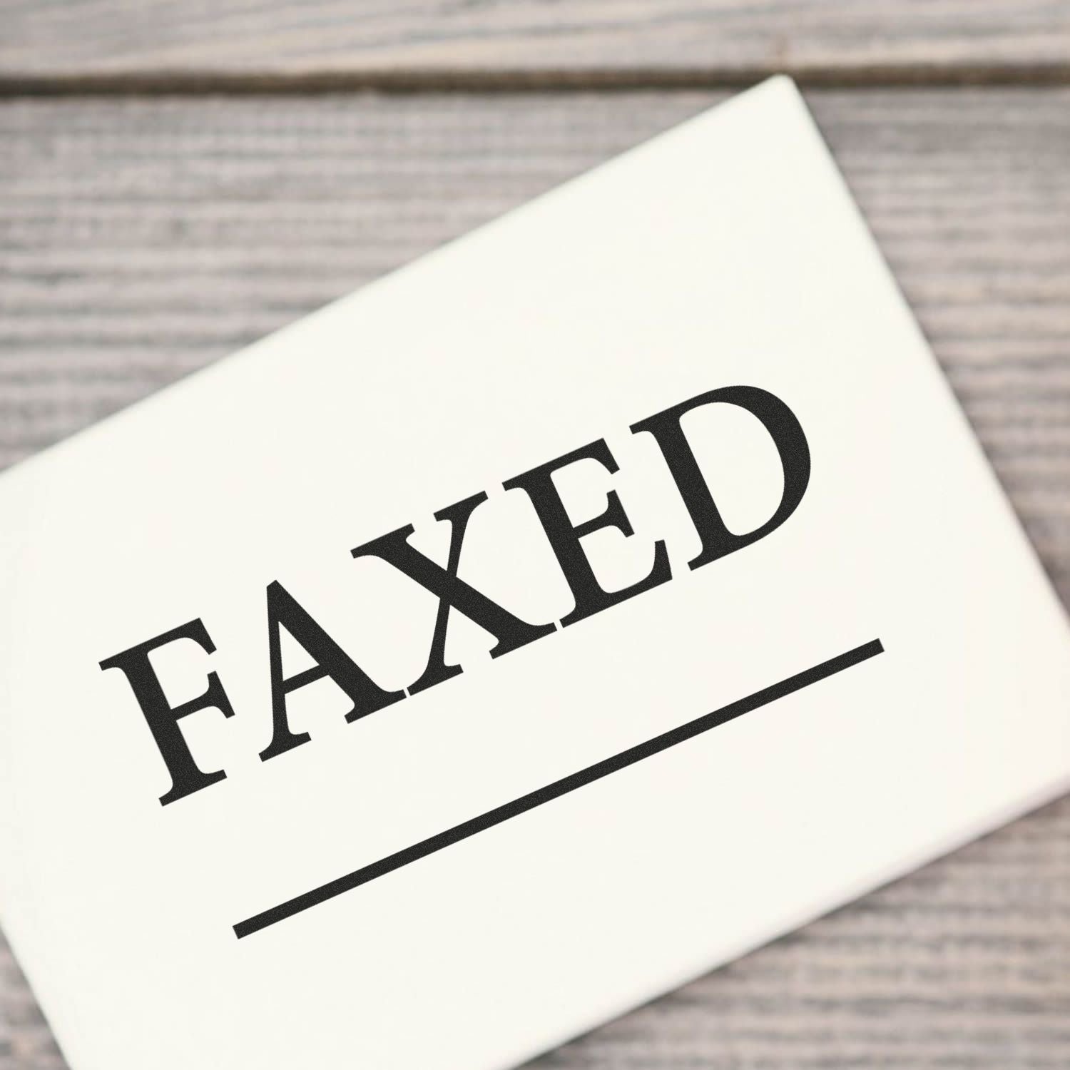 Times Faxed with Line Rubber Stamp on white paper, showing the word 'FAXED' in bold letters with a line underneath.