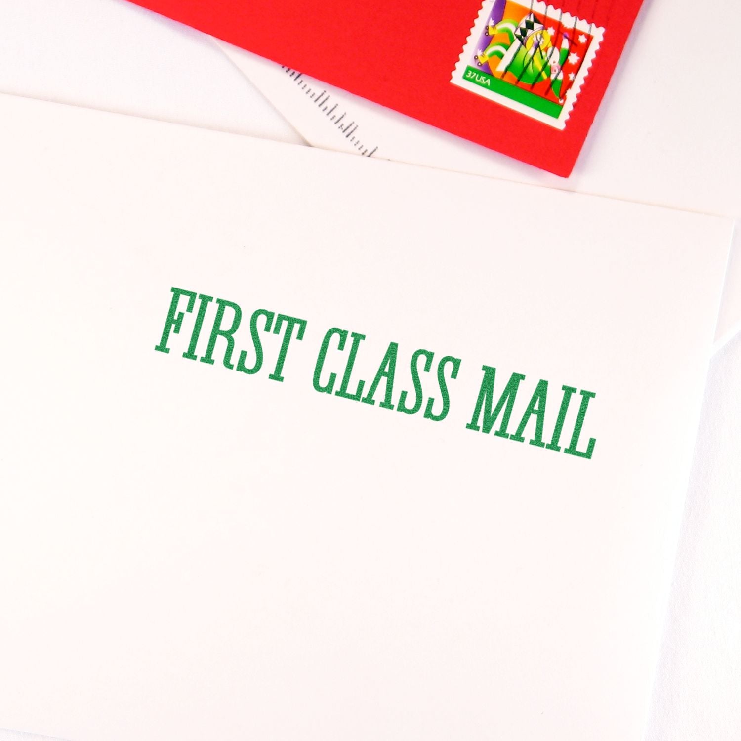 Times First Class Mail Rubber Stamp used on a white envelope with green text, next to a red envelope with a stamp.