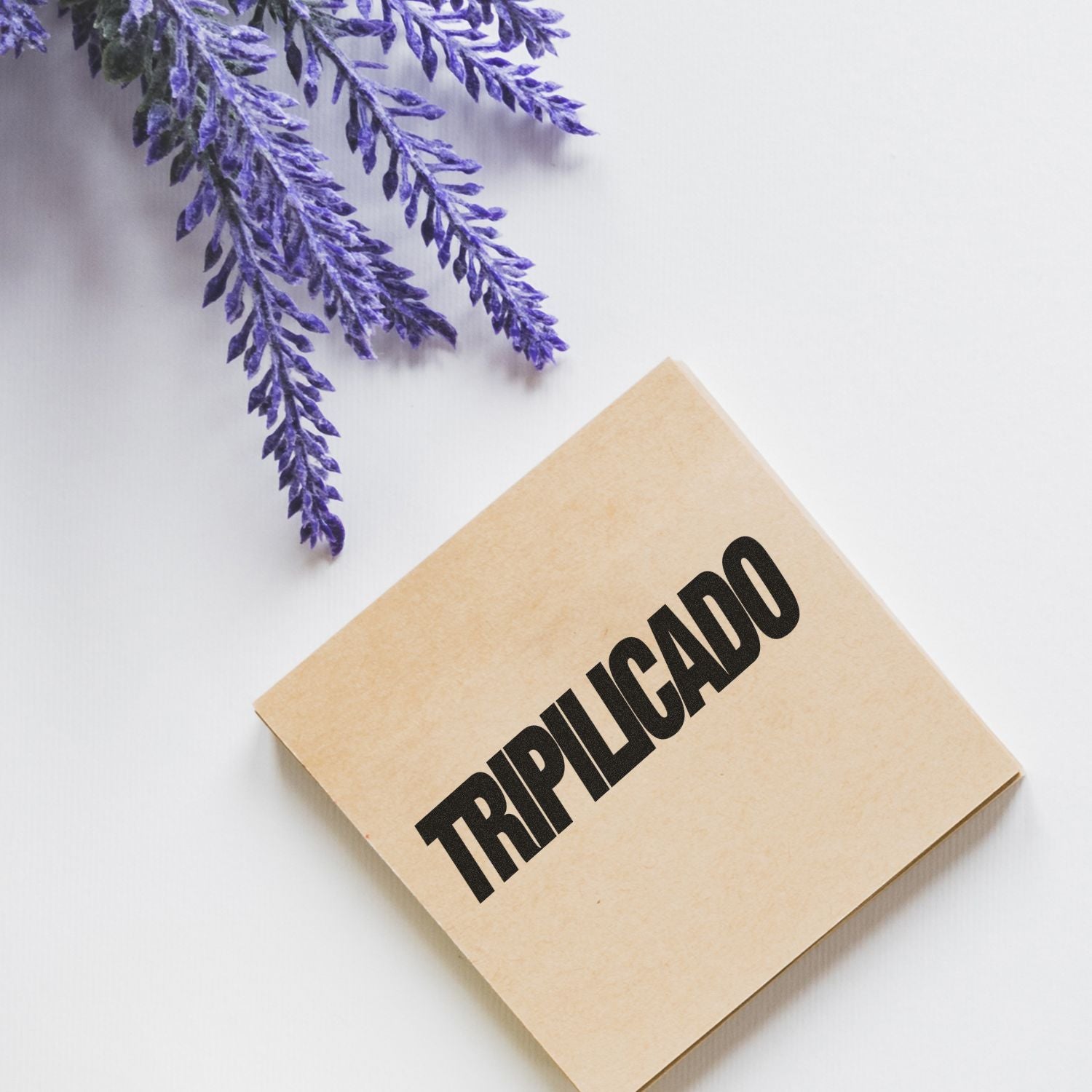 Slim Pre-Inked Tripilicado Stamp on a beige box with purple lavender flowers in the background.