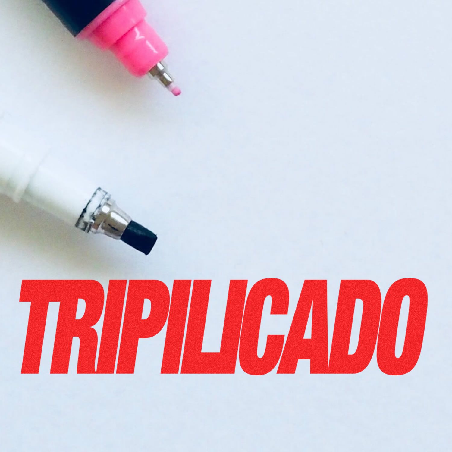 Two pen tips, one pink and one black, above the bold red text TRIPILICADO. The Self Inking Tripilicado Stamp is prominently featured.