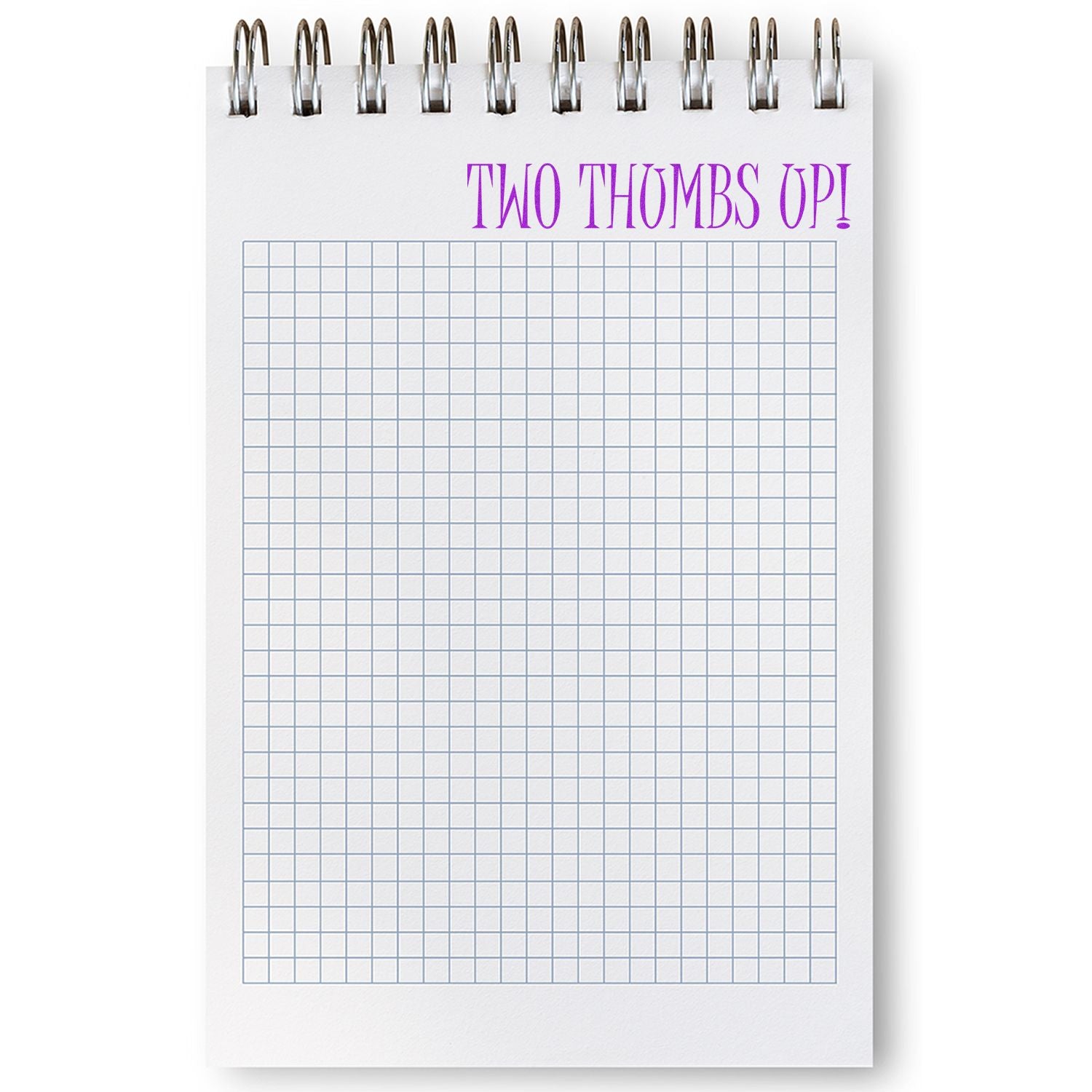 Spiral notebook with a grid pattern and a 'Two Thumbs Up' rubber stamp impression in purple at the top of the page.