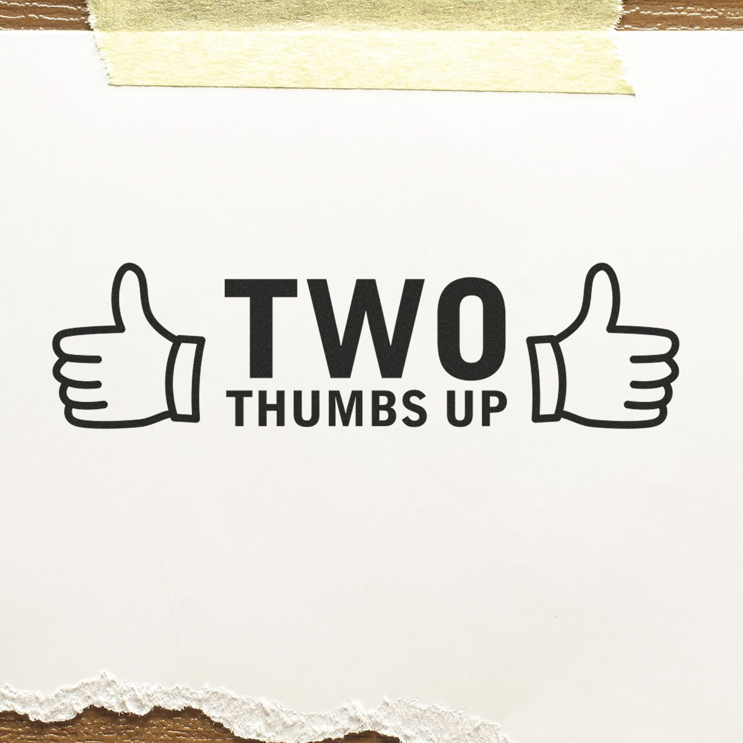 Two Thumbs Up with Thumb Icon Rubber Stamp on white paper, taped at the top, with torn edges at the bottom.