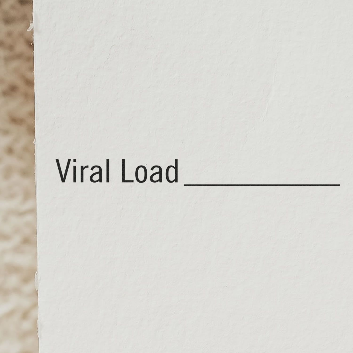 Close-up of a white paper stamped with 'Viral Load' and a blank line for filling in details, using a rubber stamp.