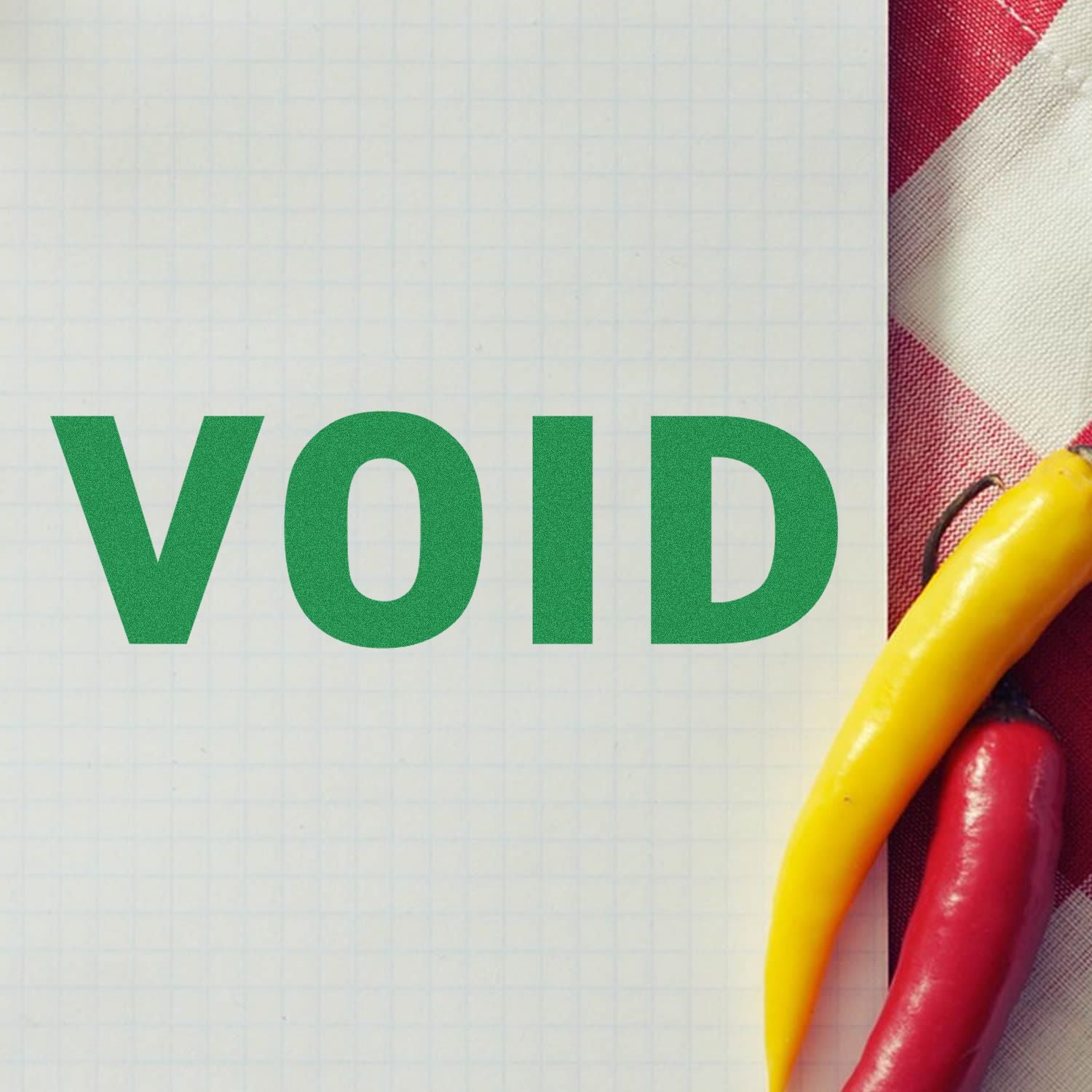 Slim Pre-Inked Void Stamp marking VOID in green on graph paper, with yellow and red chili peppers on the side.