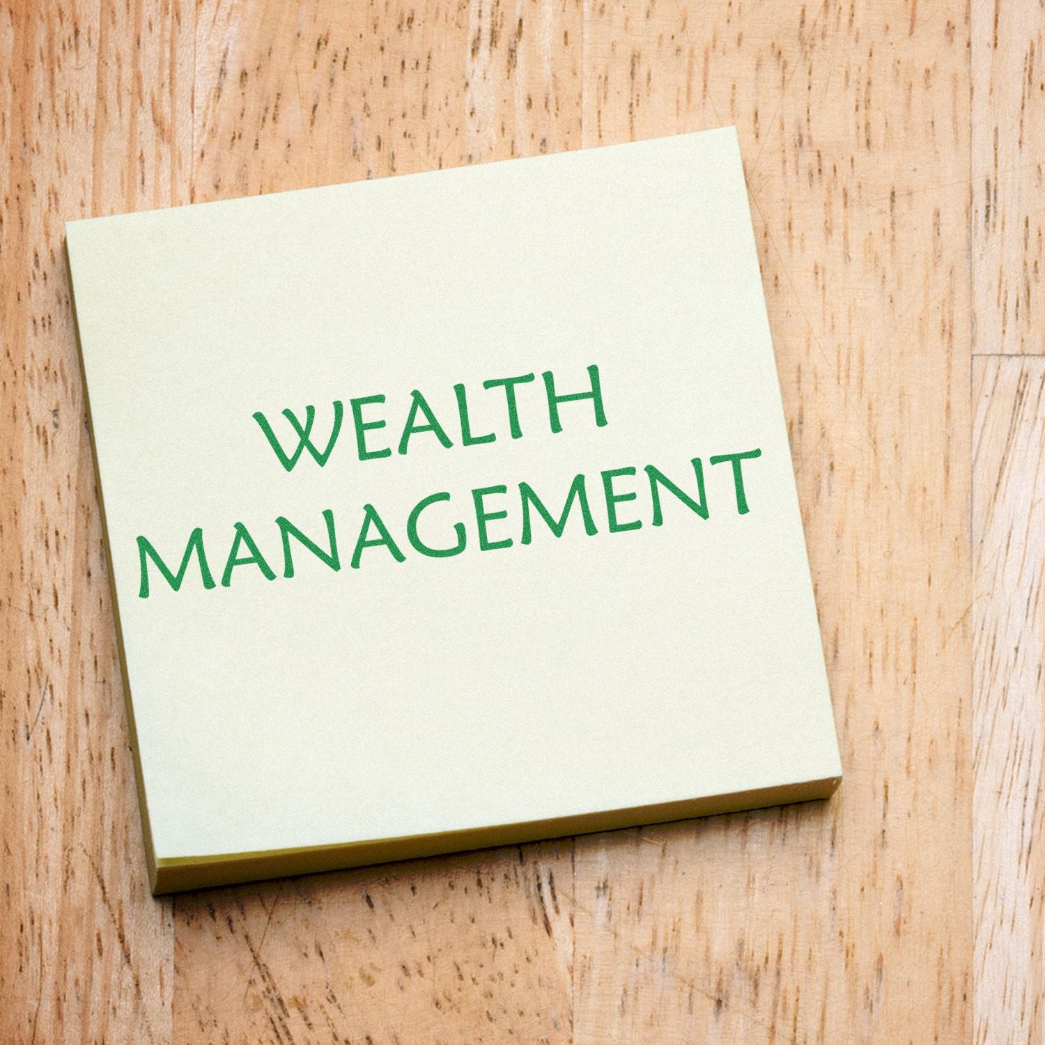 Self Inking Wealth Management Stamp used on a yellow sticky note with Wealth Management text, placed on a wooden surface.