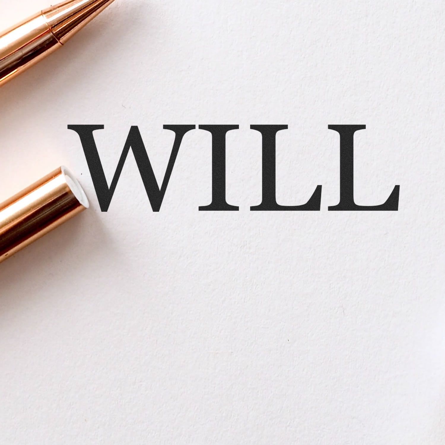 A Self Inking Will Stamp imprint on white paper next to a gold pen, showcasing the word WILL in bold, black letters.