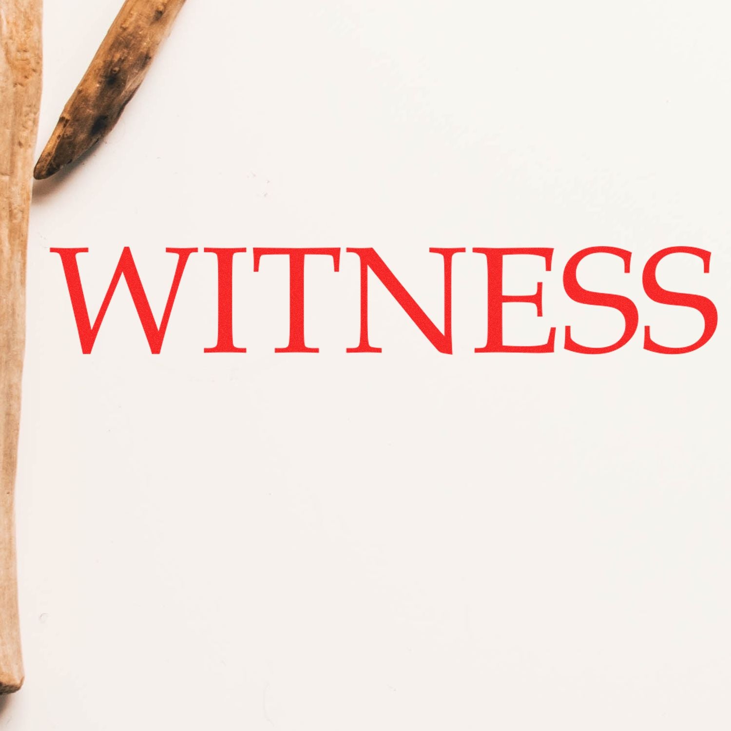 Red 'WITNESS' text stamped on white paper using a Slim Pre-Inked Witness Stamp, with a wooden object partially visible on the left.